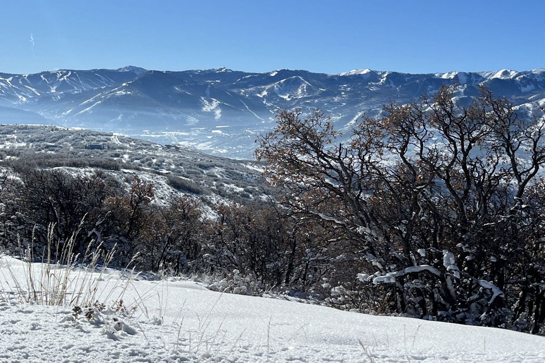 Snow-covered terrain with distant mountains and a clear sky