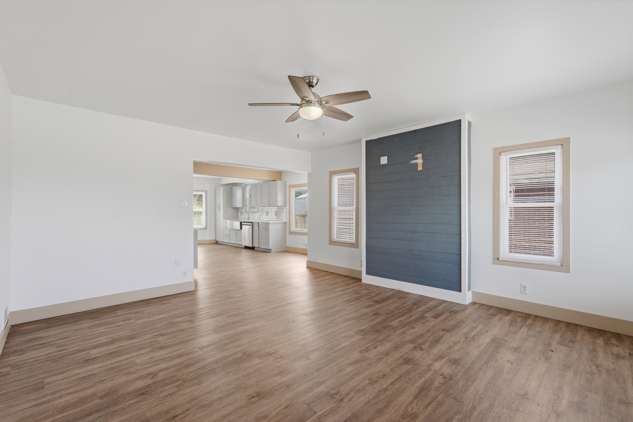 Open concept living space featuring wood-finish flooring and a contemporary ceiling fan