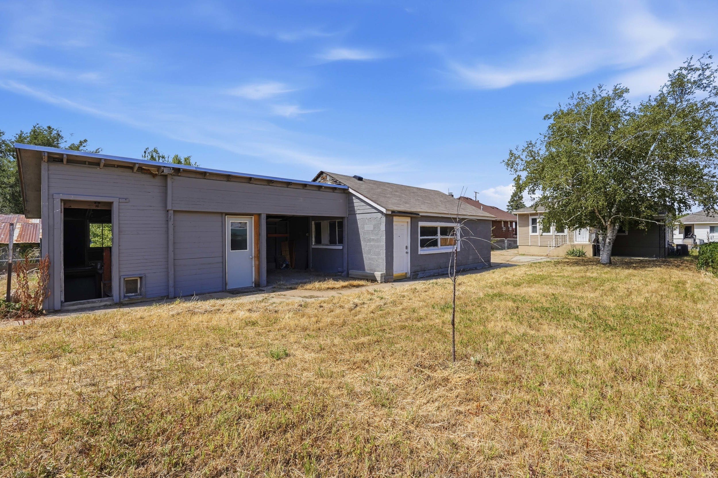 Expansive rear yard with a mature tree, offering ample outdoor space