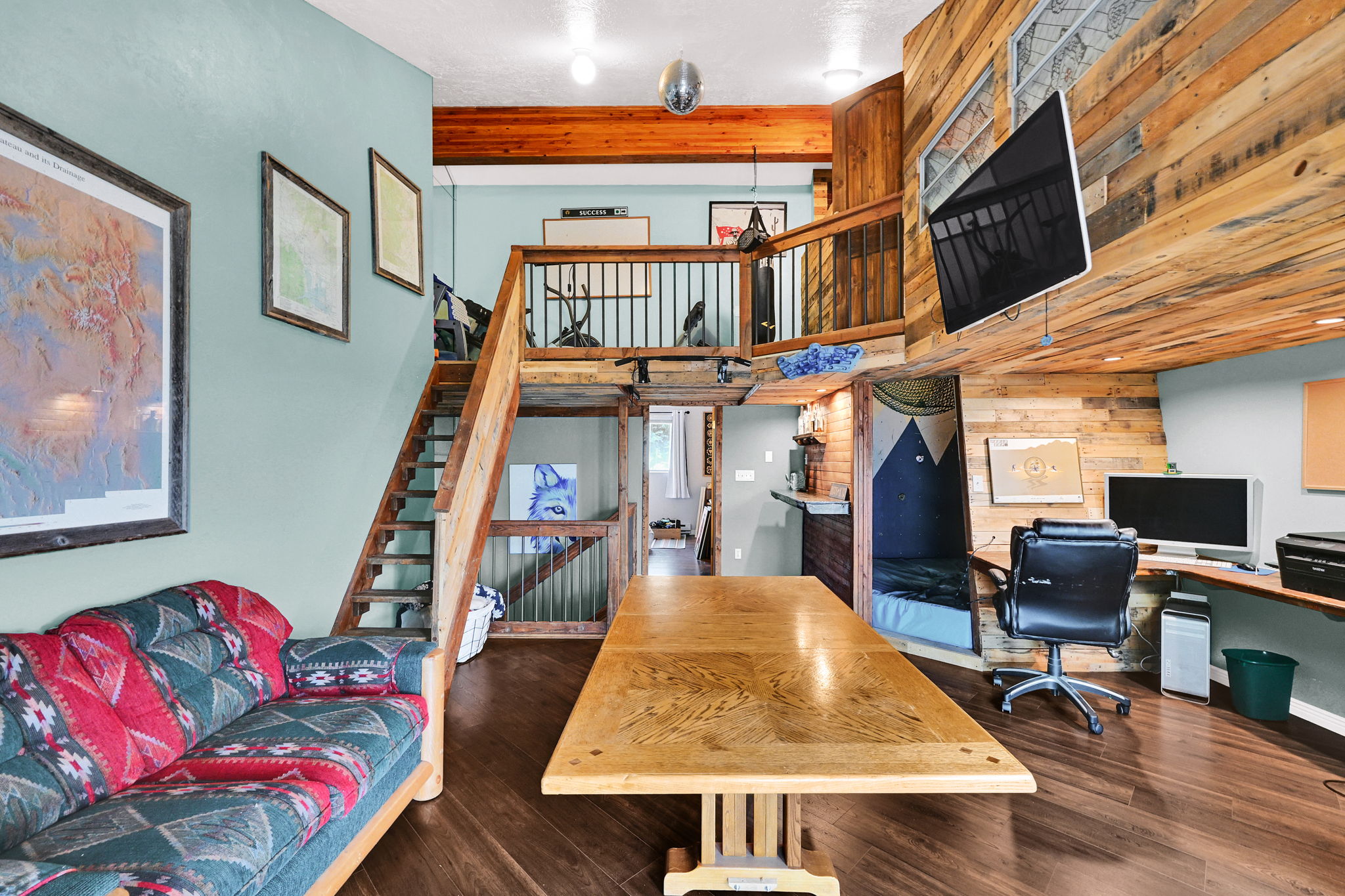 Interior space featuring dark wood-finish flooring, a built-in wood-paneled workstation, and a wood-paneled accent wall