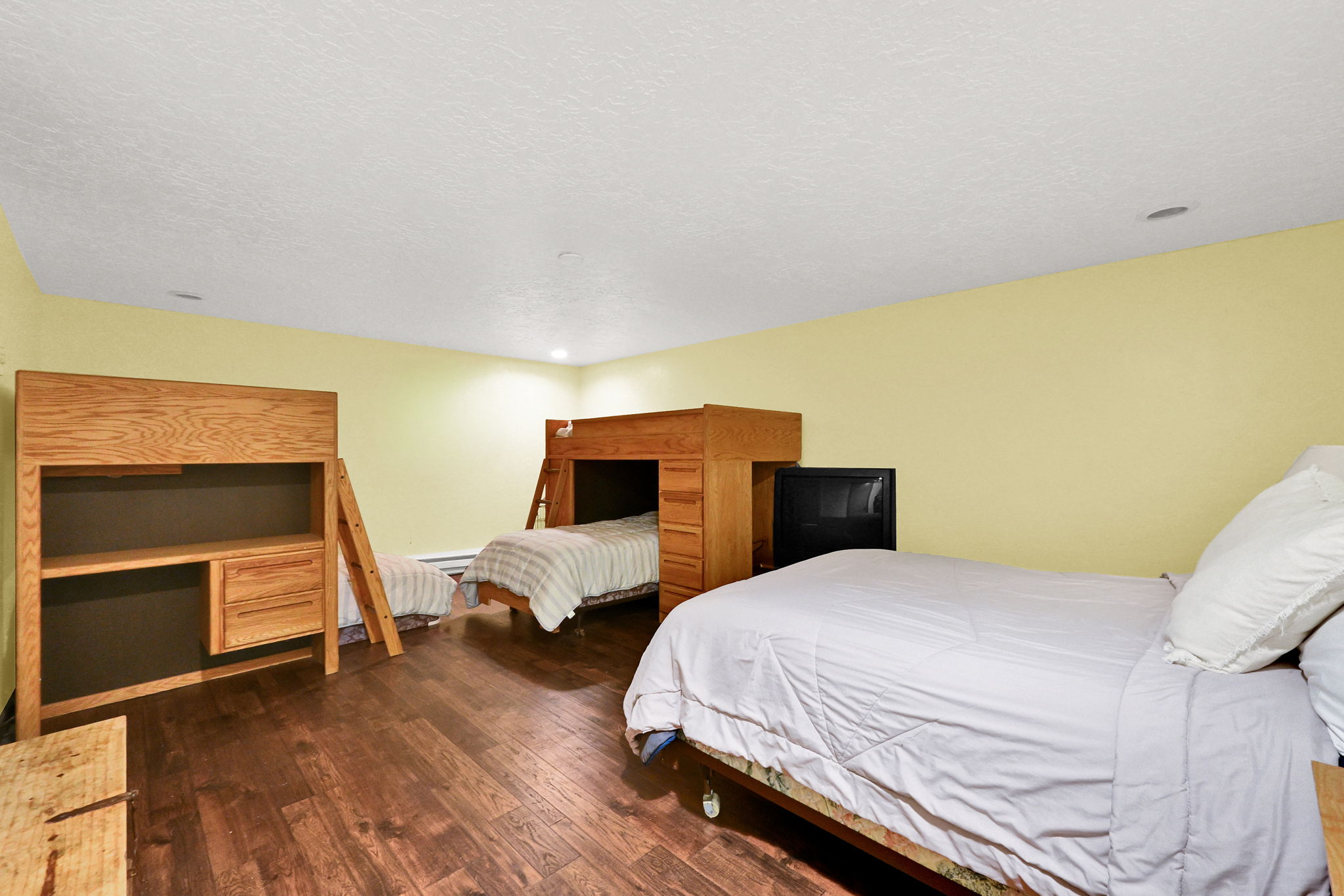 Bedroom featuring wood-finish flooring, recessed lighting, and light yellow wall paint