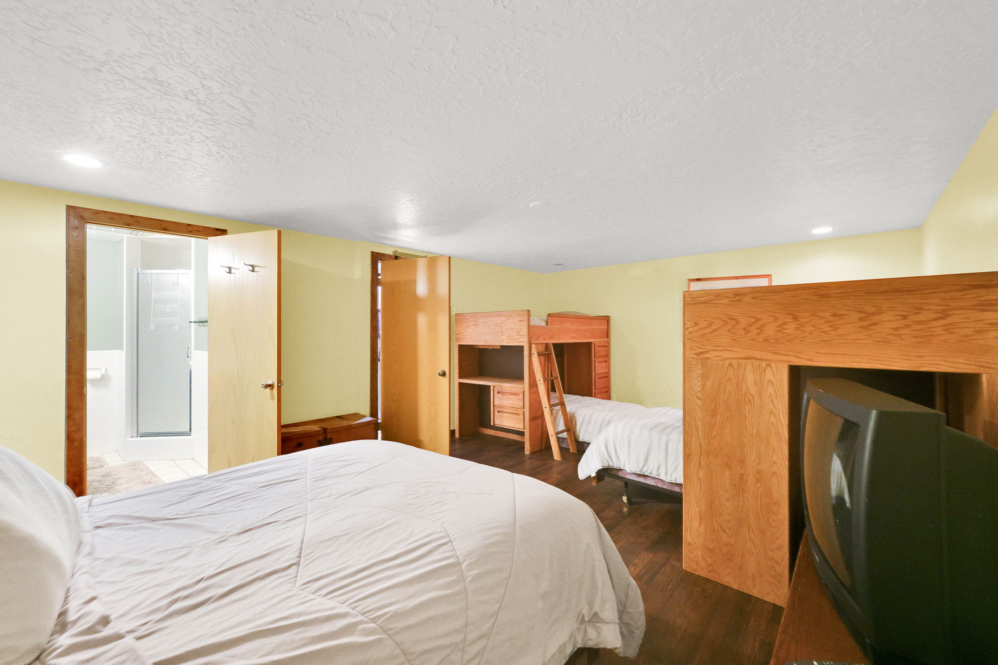 Bedroom featuring wood-finish flooring, light yellow walls, recessed lighting, and a built-in bunk bed structure
