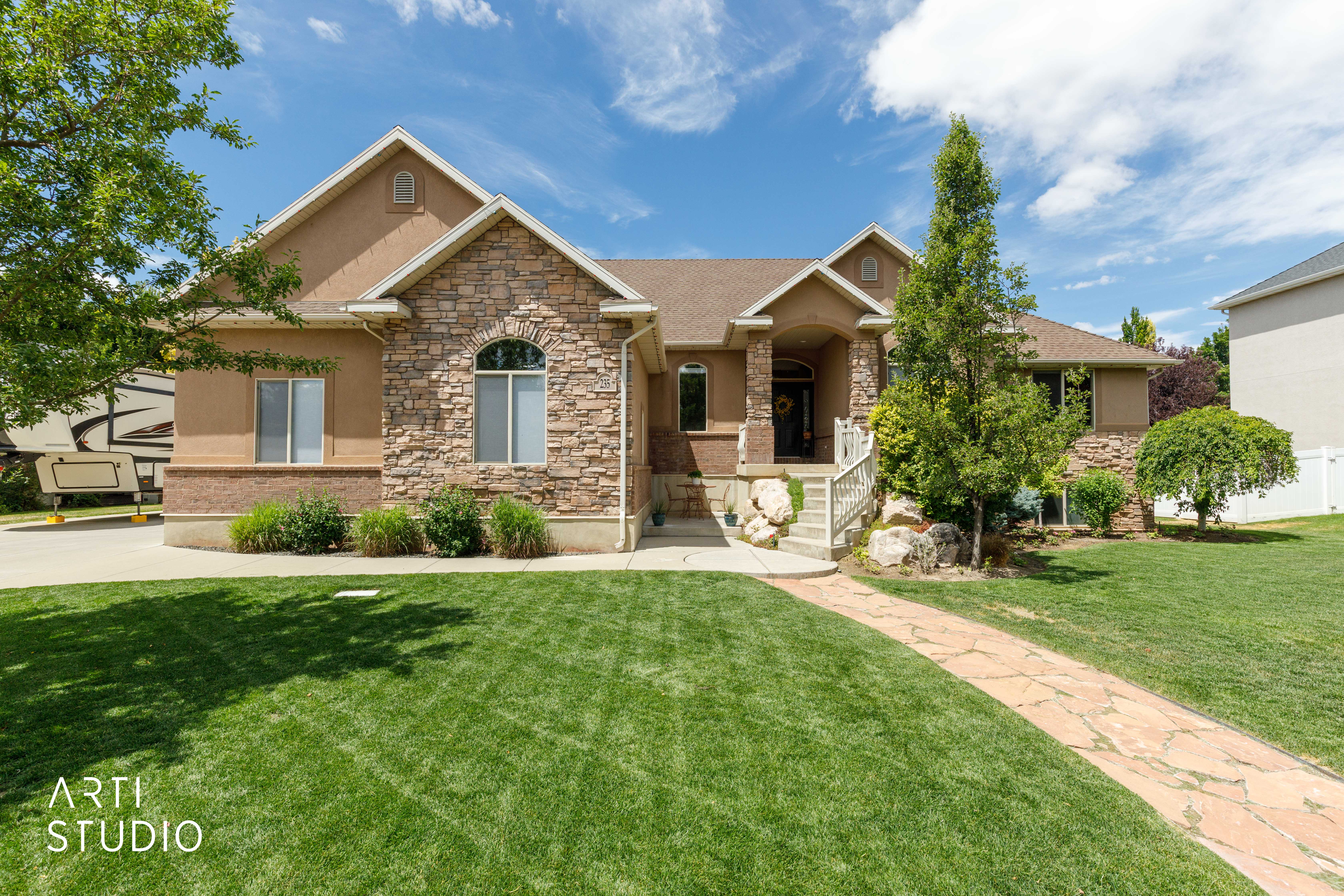Stucco and stone facade with arched window accents
