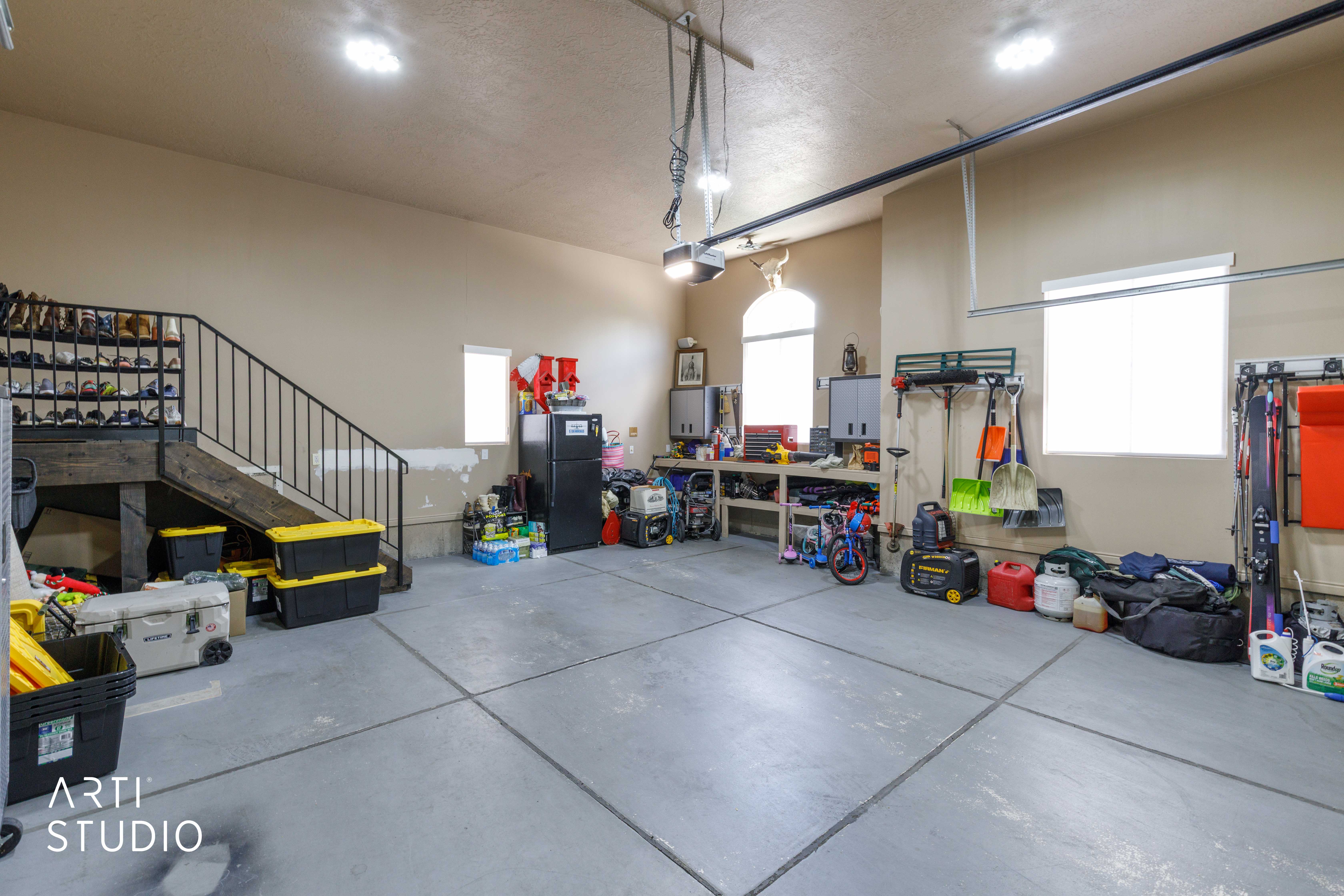 Extra wide garage featuring concrete flooring and ample overhead lighting