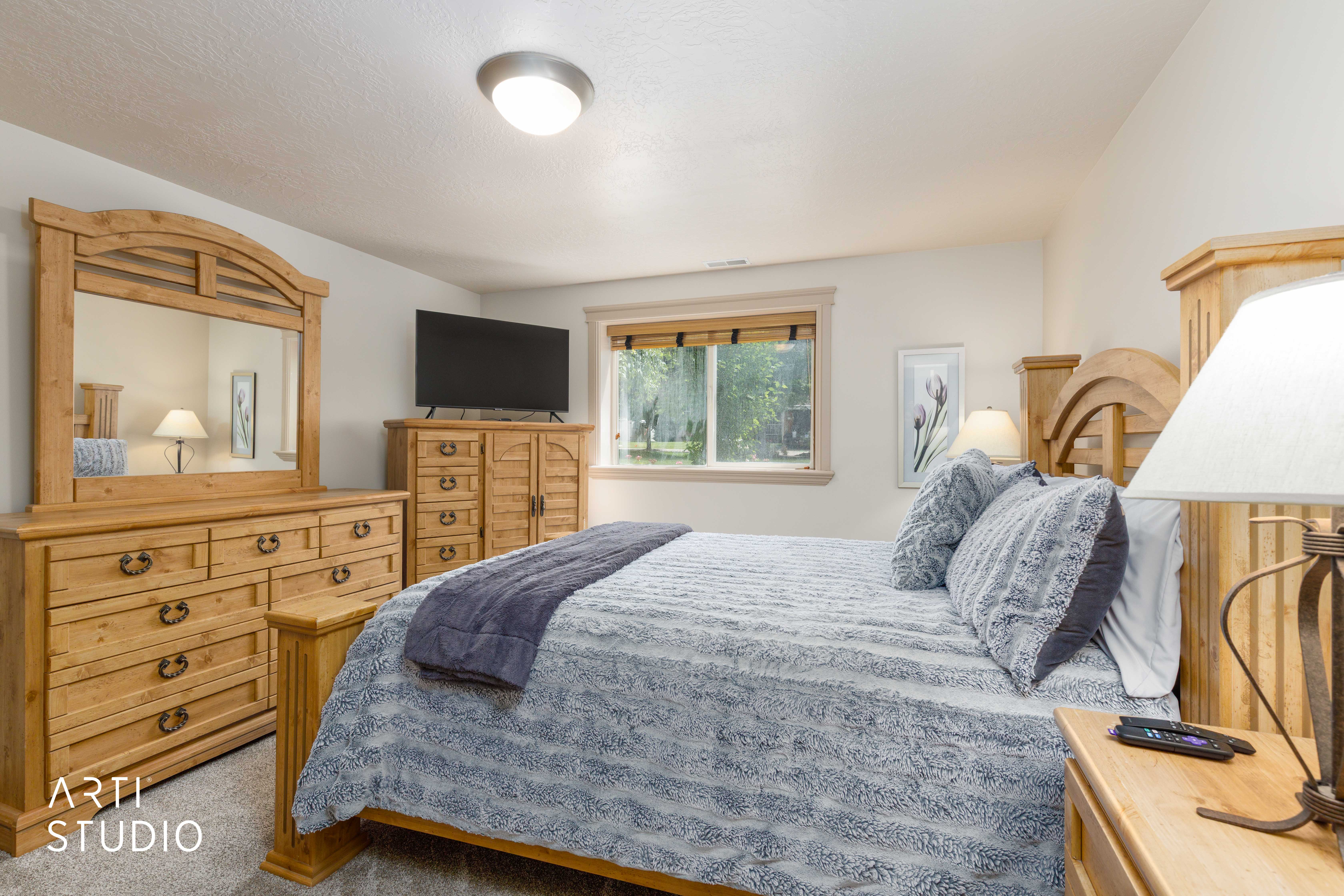 spacious bedroom with large window and carpet