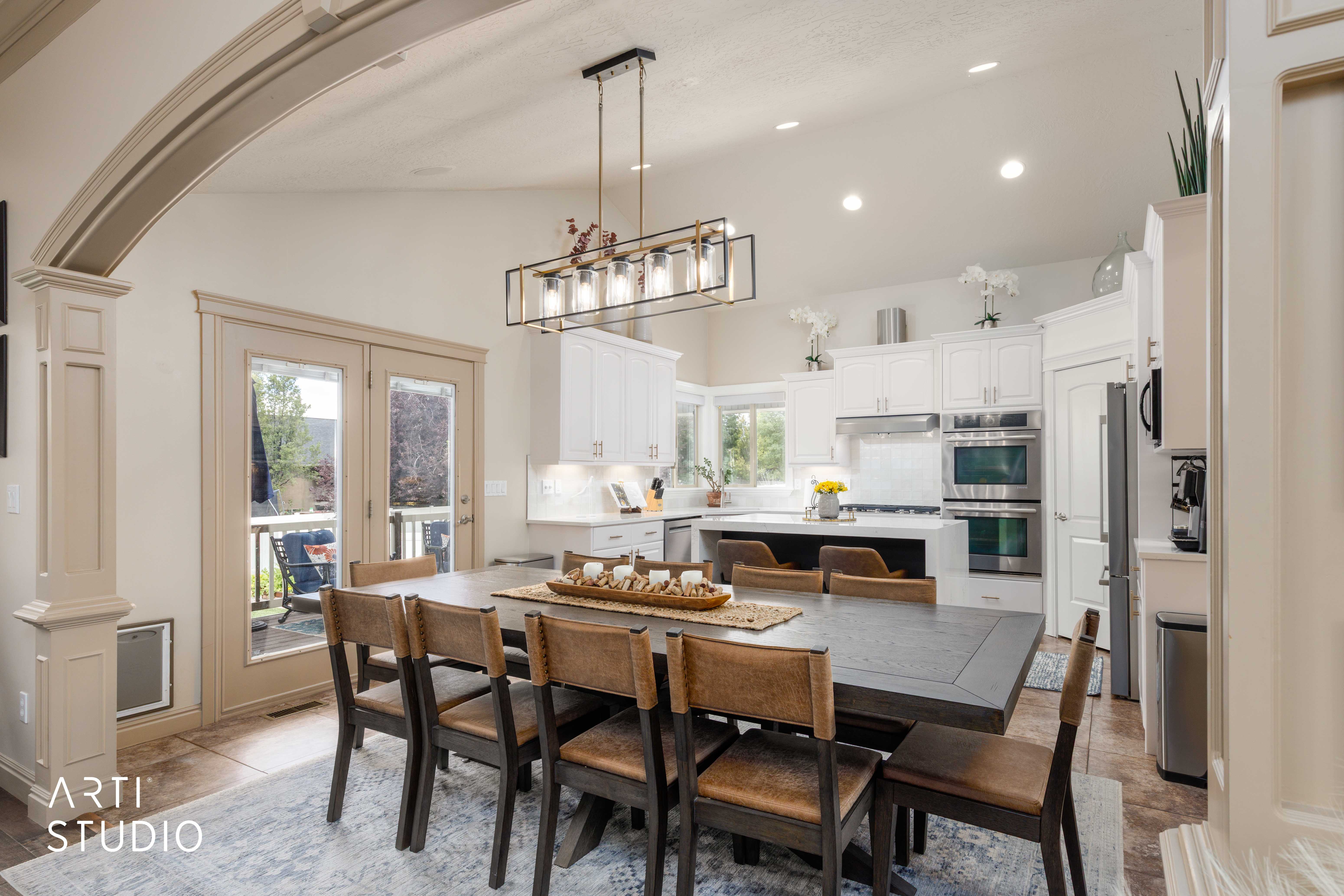 Dining area featuring an arched entryway and double French doors to an outdoor patio