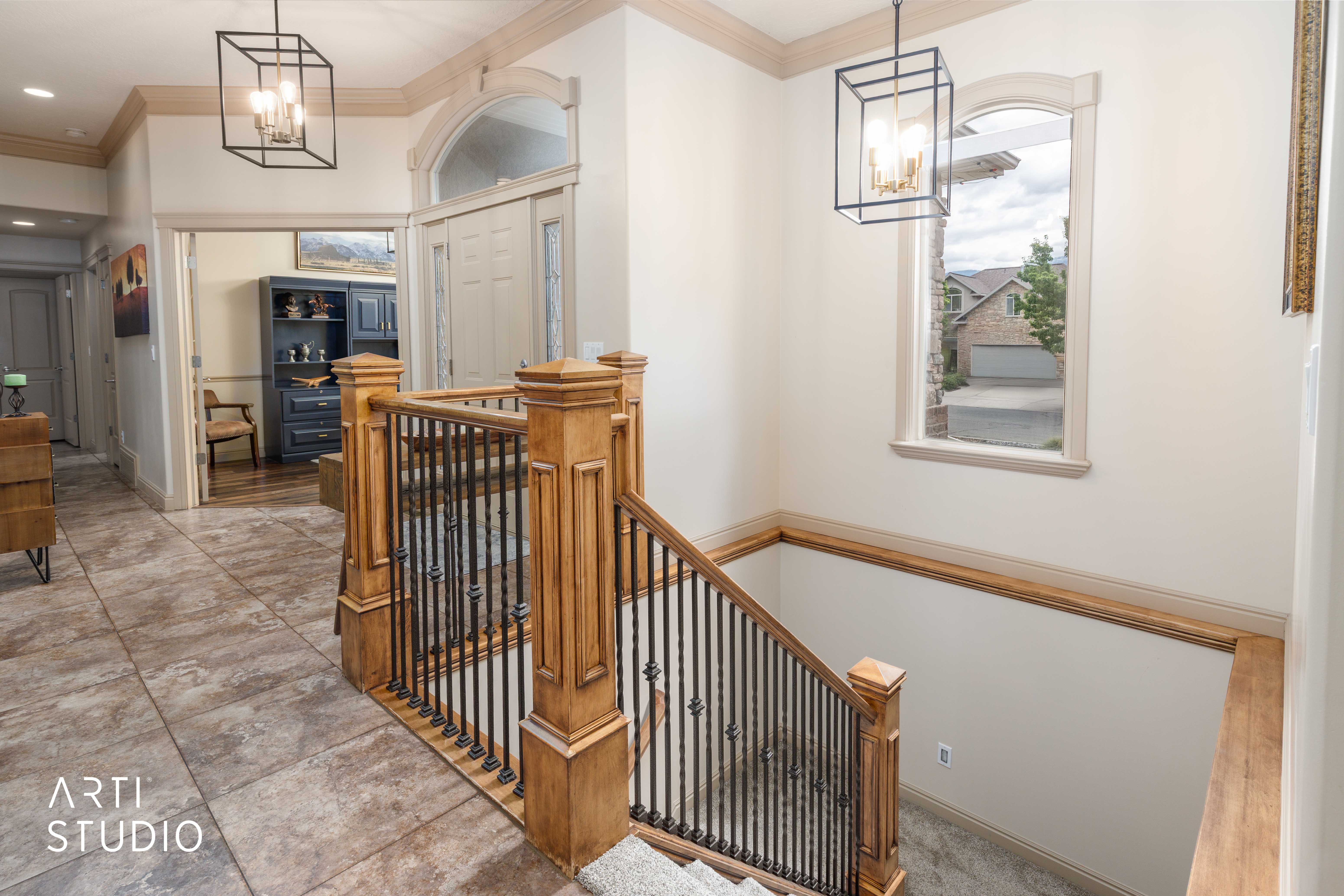 Entry foyer featuring a grand staircase with wood newel posts and wrought iron balusters