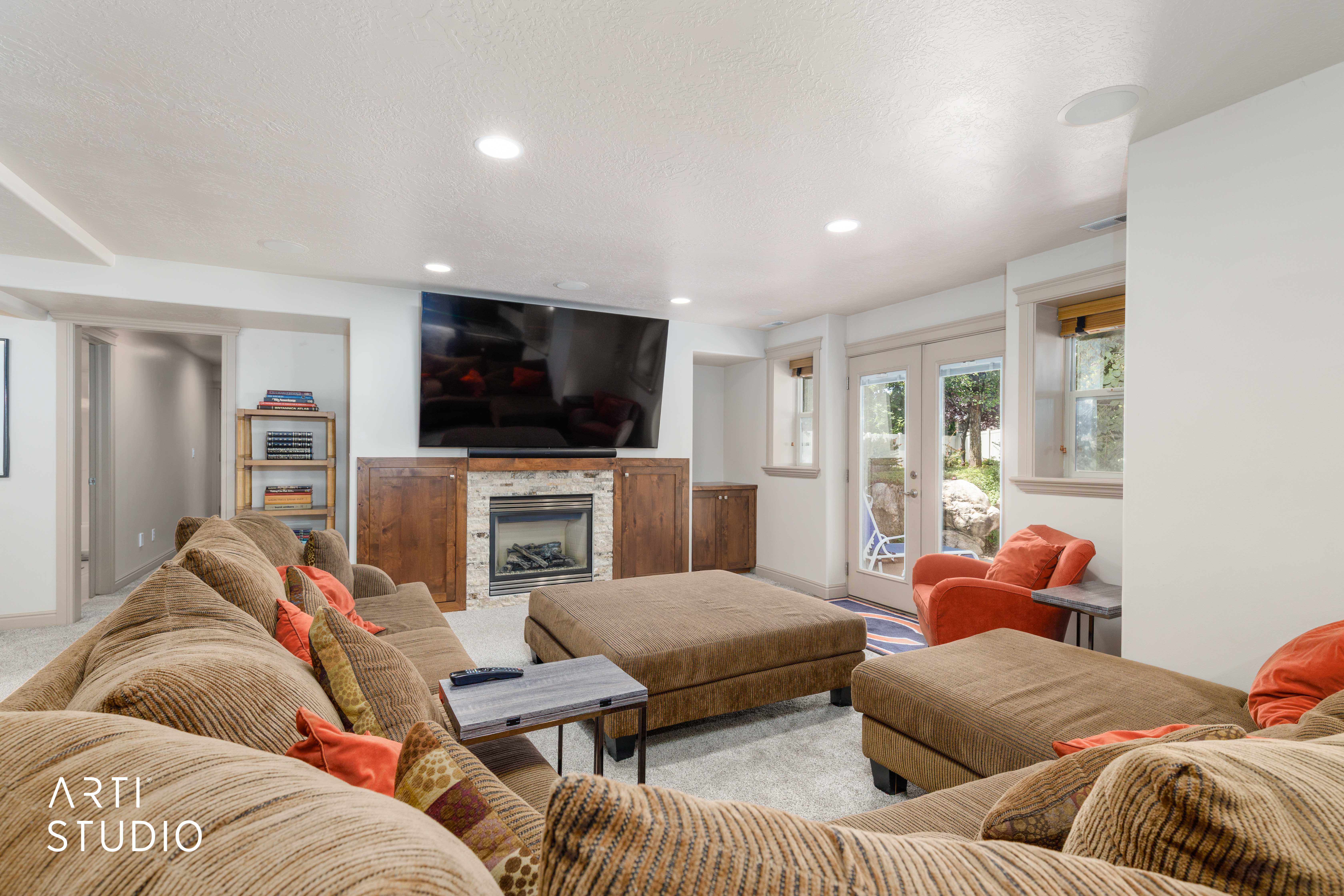 Built-in fireplace with a stone surround and french doors walk-out to backyard