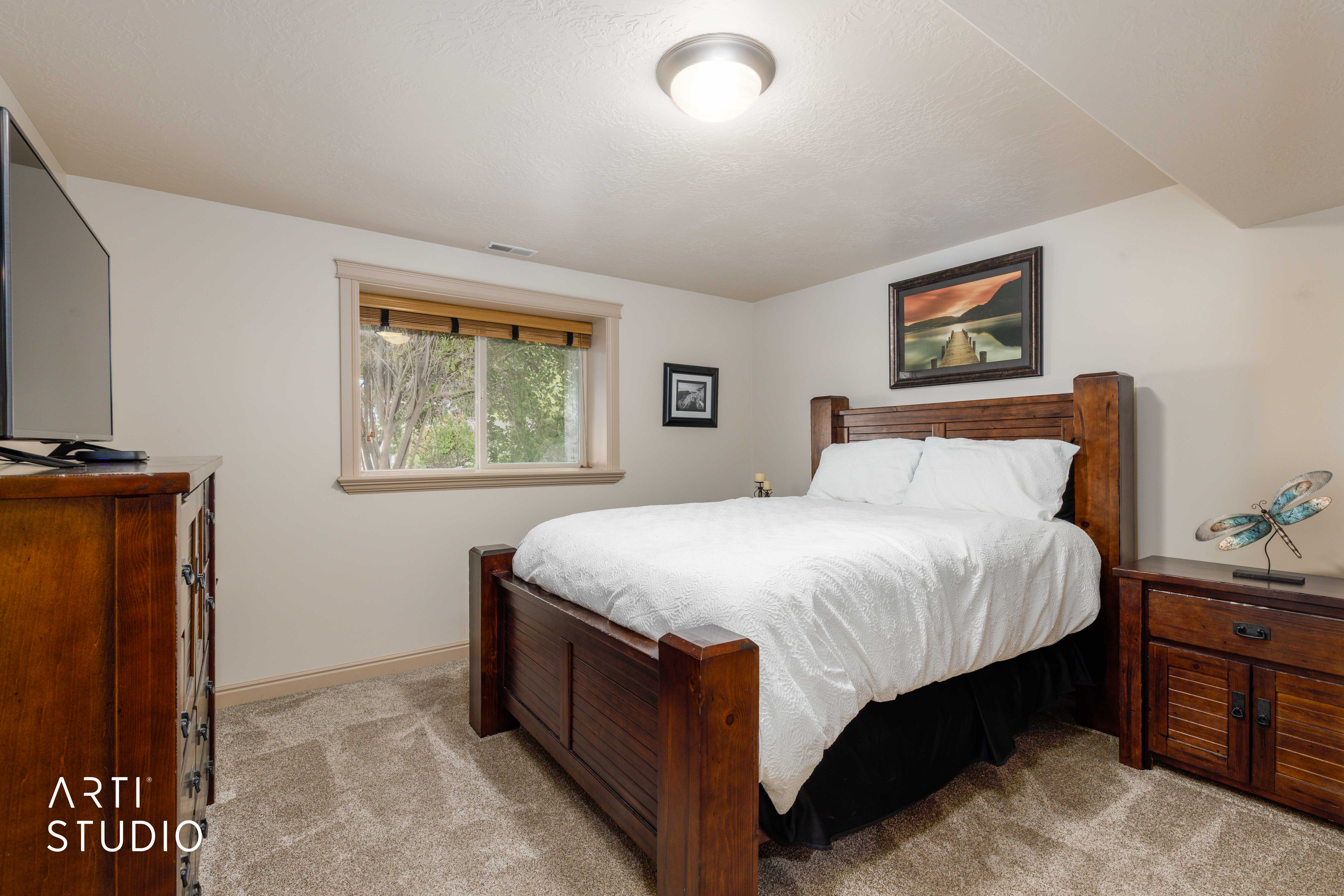 Carpeted, spacious bedroom with large window
