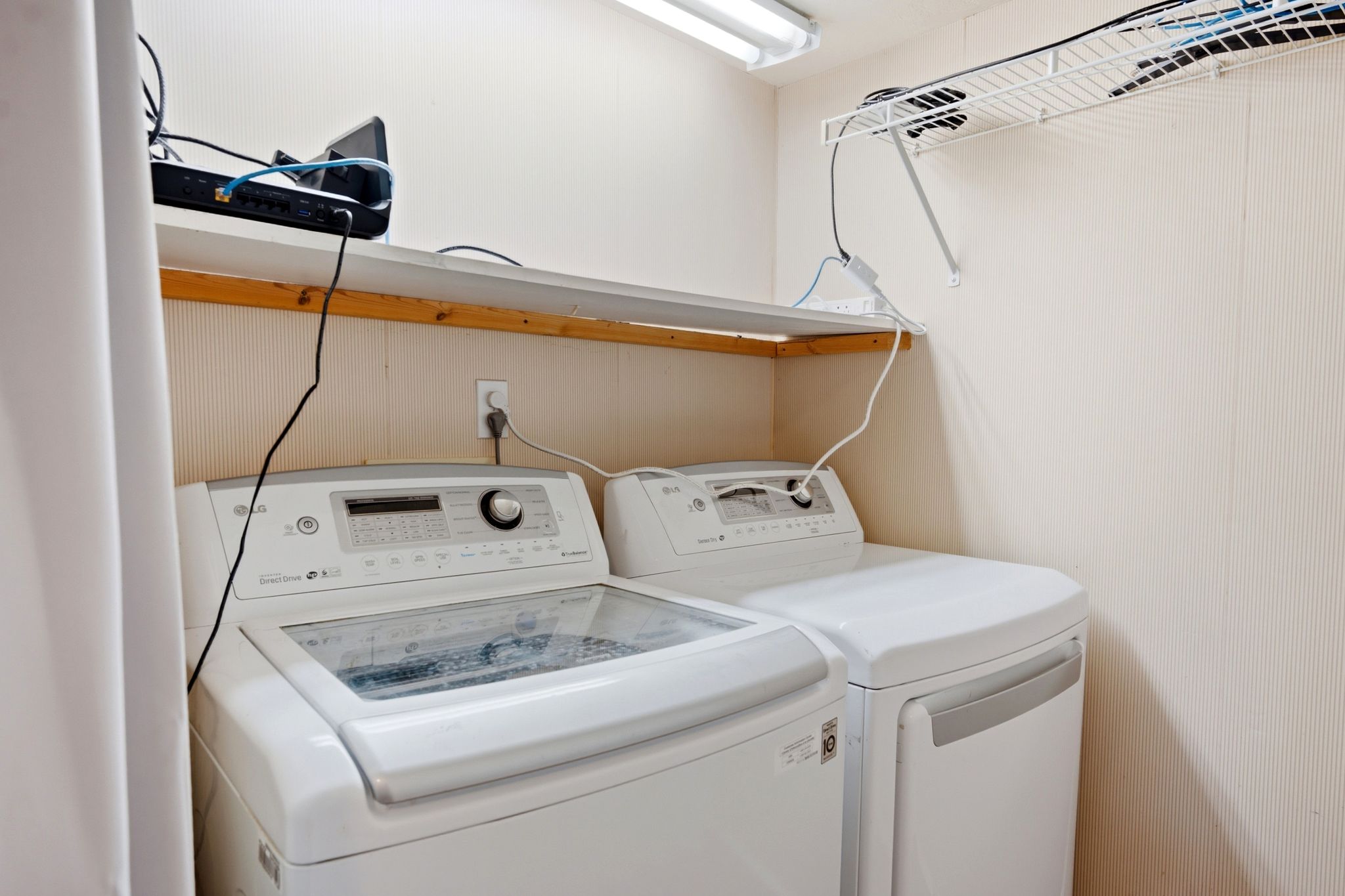 Laundry area featuring a top-load washer, a front-load dryer, and a wall-mounted shelving system