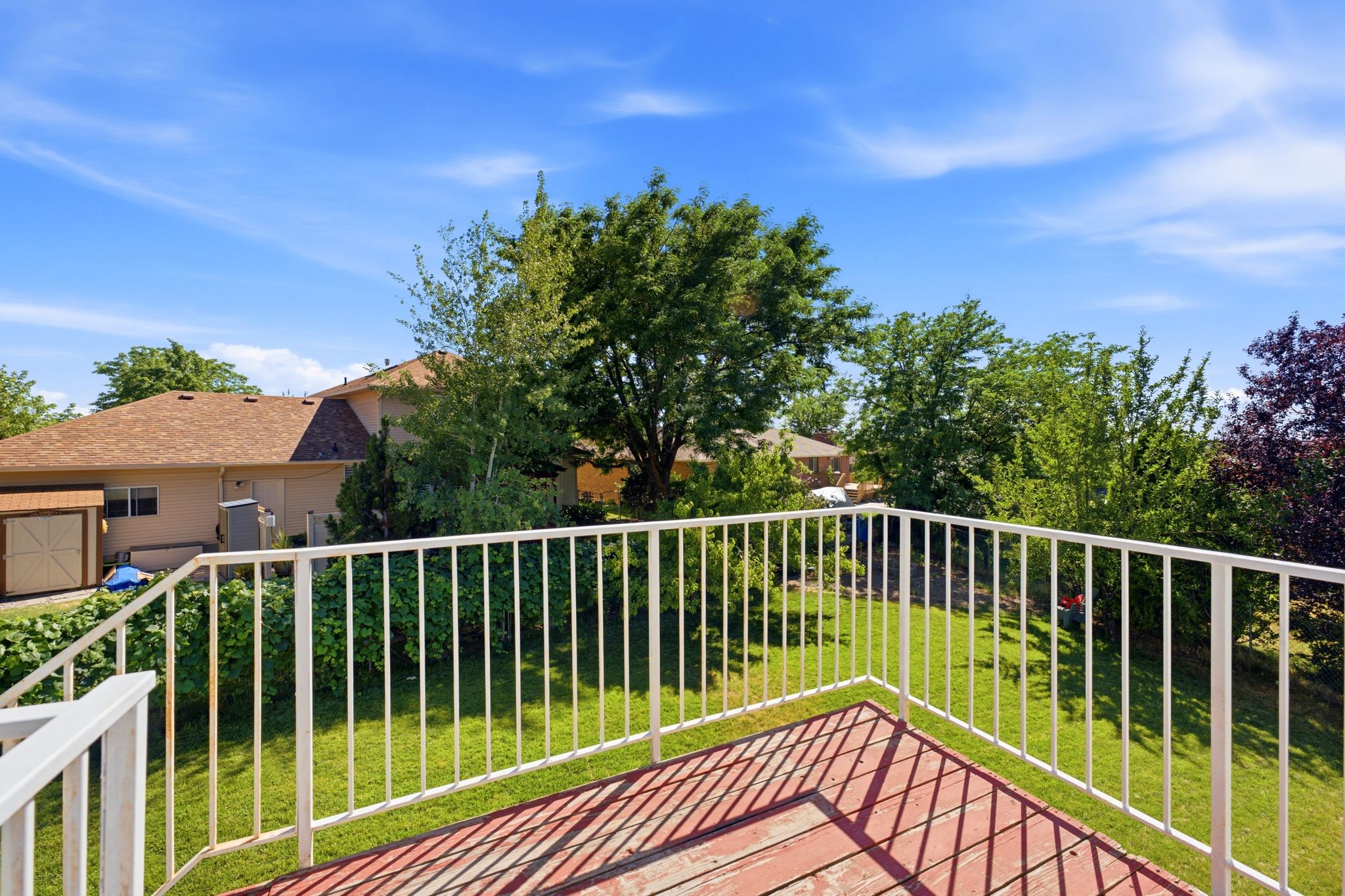 Outdoor deck featuring a wood-finish surface and a white metal railing