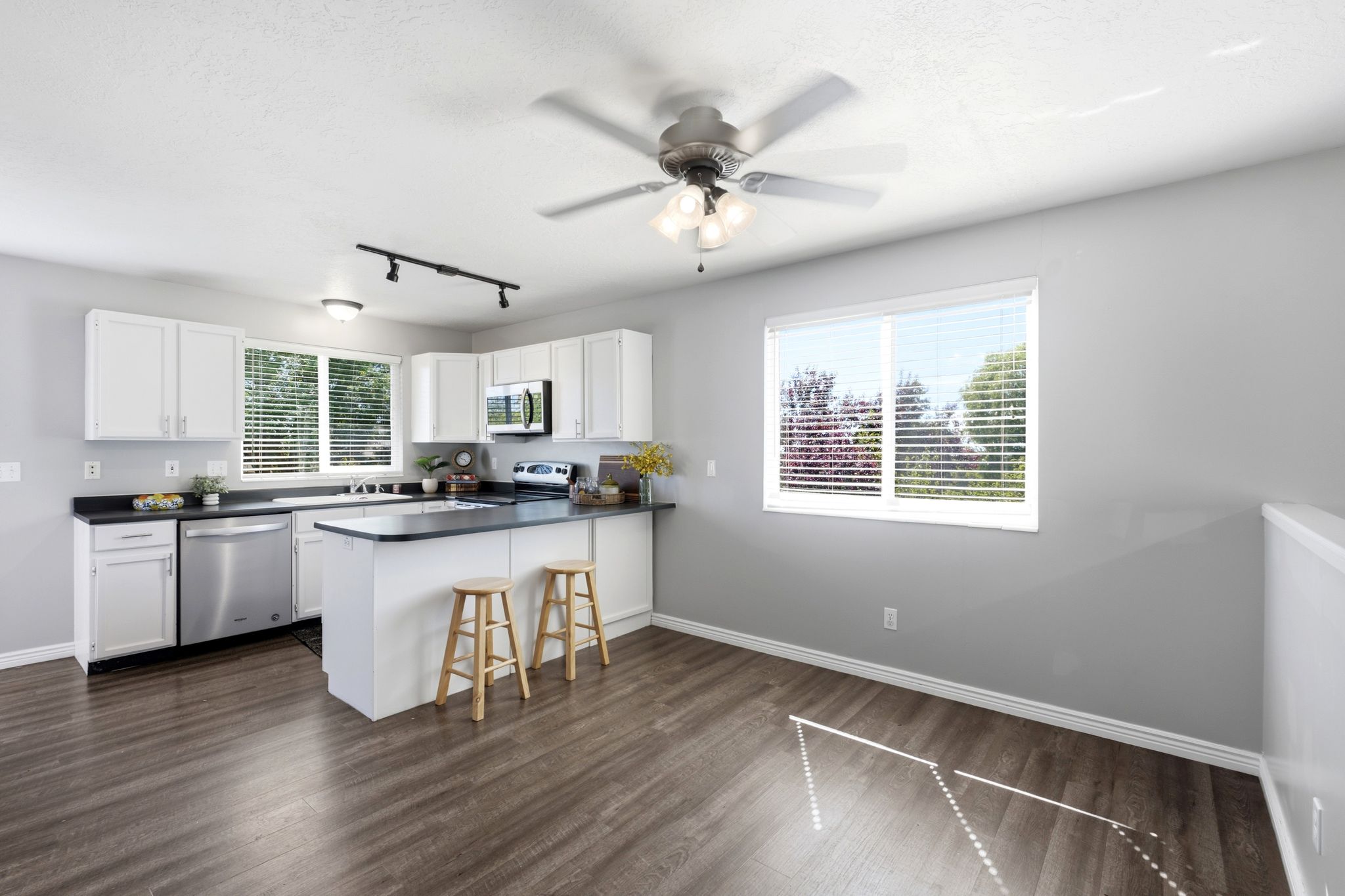 Kitchen featuring white cabinetry, dark countertops, and stainless steel appliances