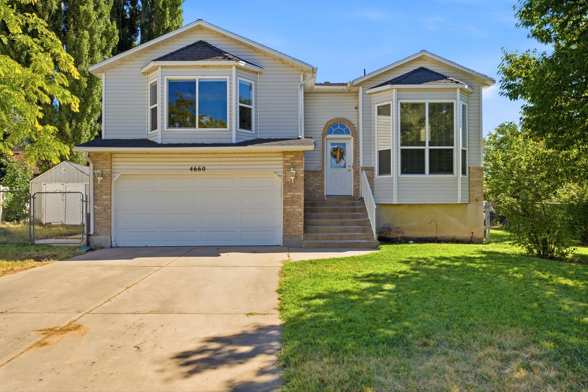 Two-story residence featuring light-colored siding and a brick-finish lower level