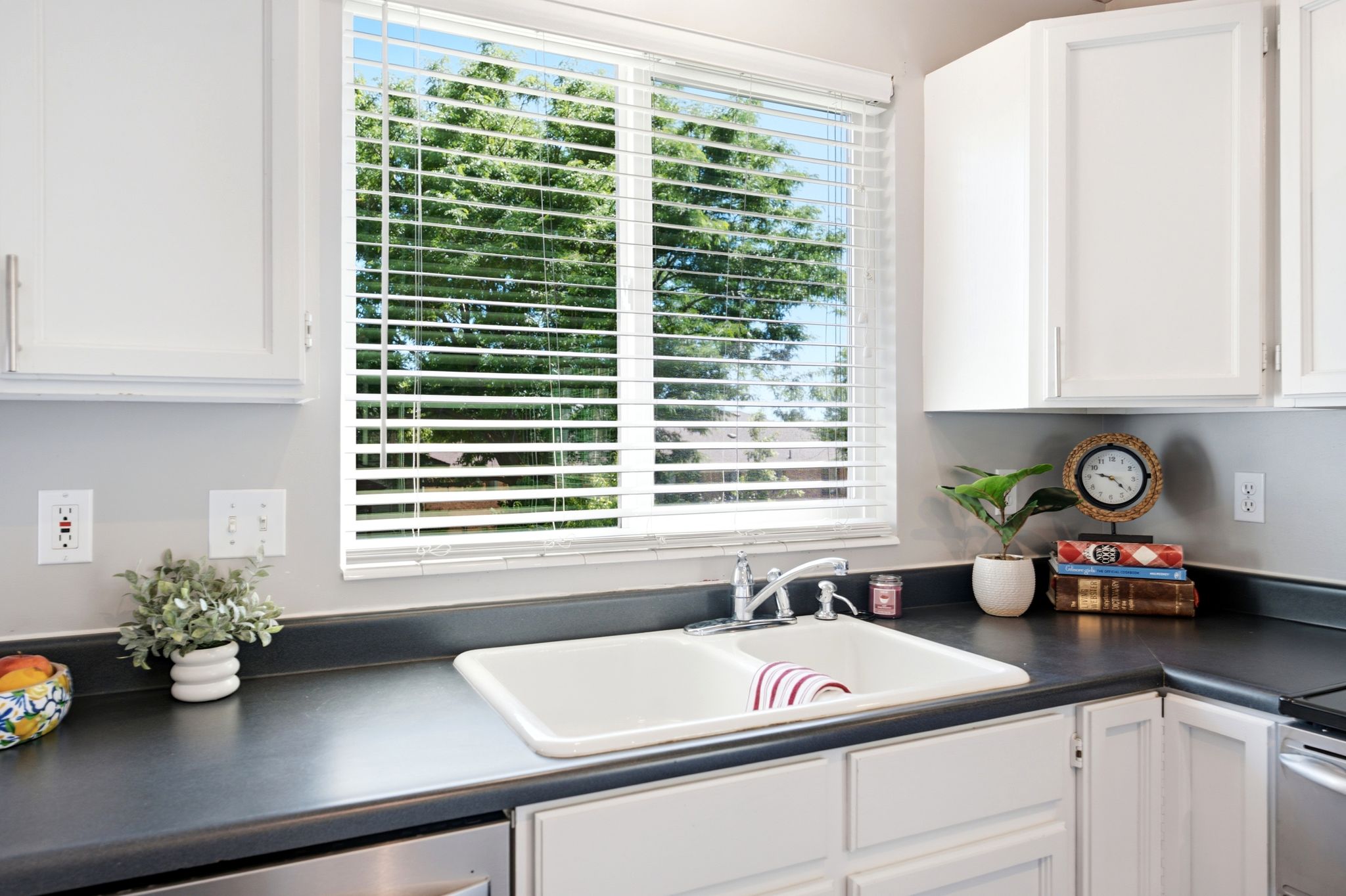 Dual-basin sink with chrome faucet set into dark countertops