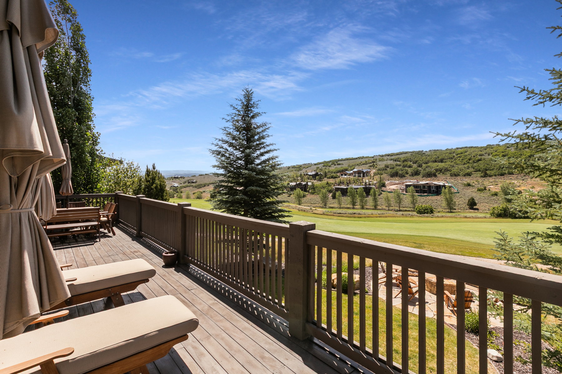 Expansive outdoor deck featuring wood-finish flooring and a full-height railing