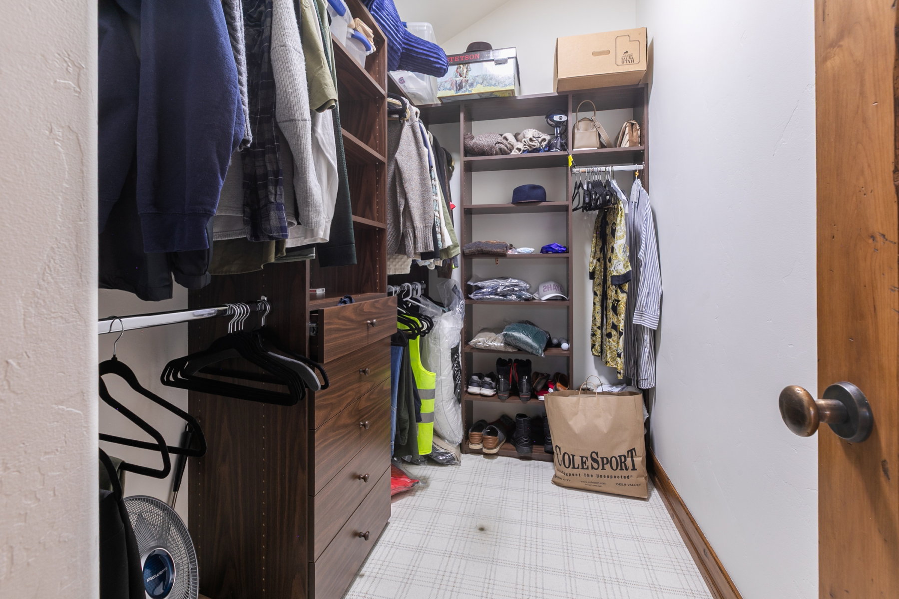 Custom-built closet system featuring wood-finish cabinetry, integrated shelving, and multiple hanging rods