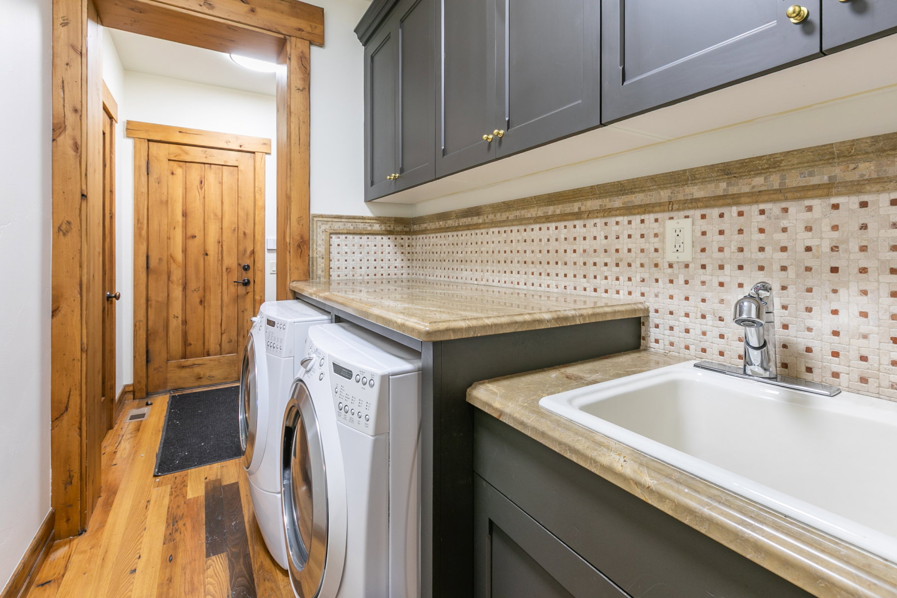 Laundry area featuring a utility sink, countertop, and upper cabinetry