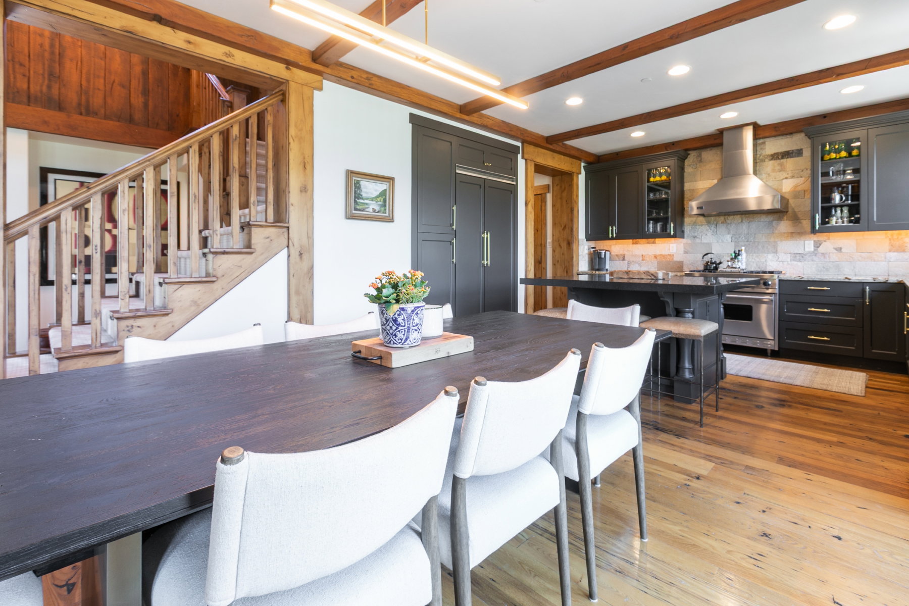 Spacious dining area featuring wood-finish flooring and exposed ceiling beams