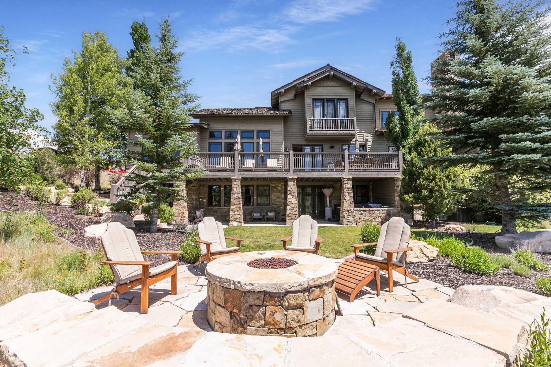 Multi-level rear exterior featuring a stone-clad lower level and an expansive upper balcony