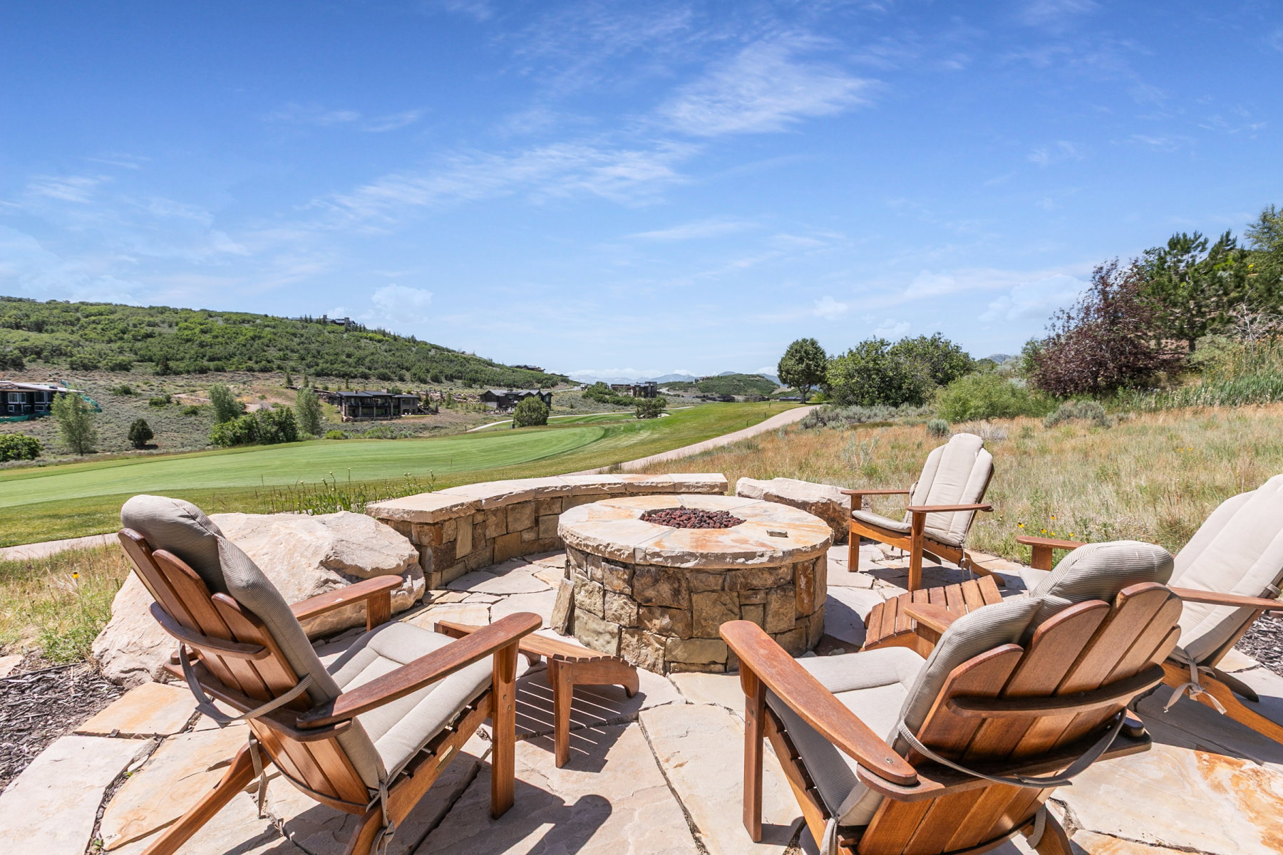 Stone patio featuring a built-in fire pit with stone surround, complemented by flagstone paving