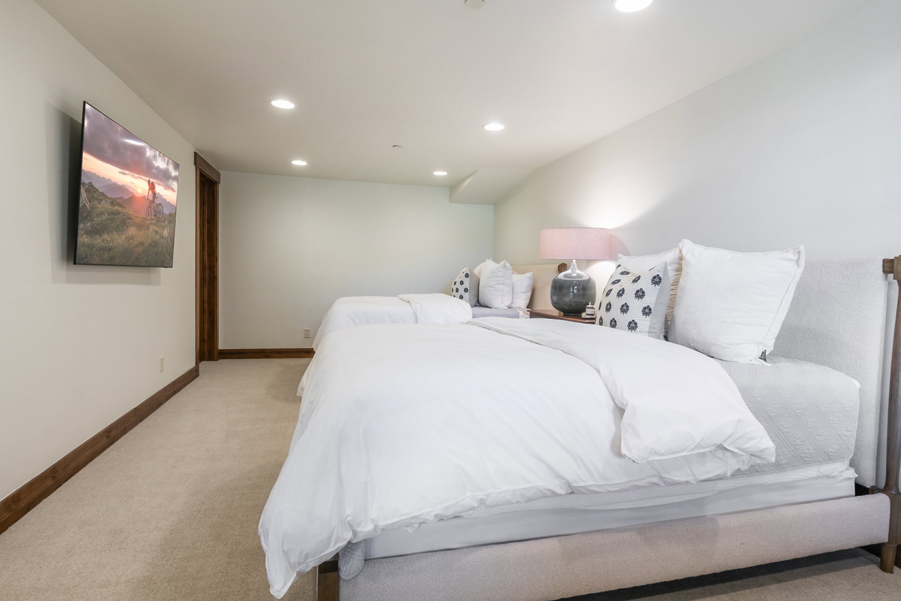 Carpeted room with recessed lighting and a wall-mounted television