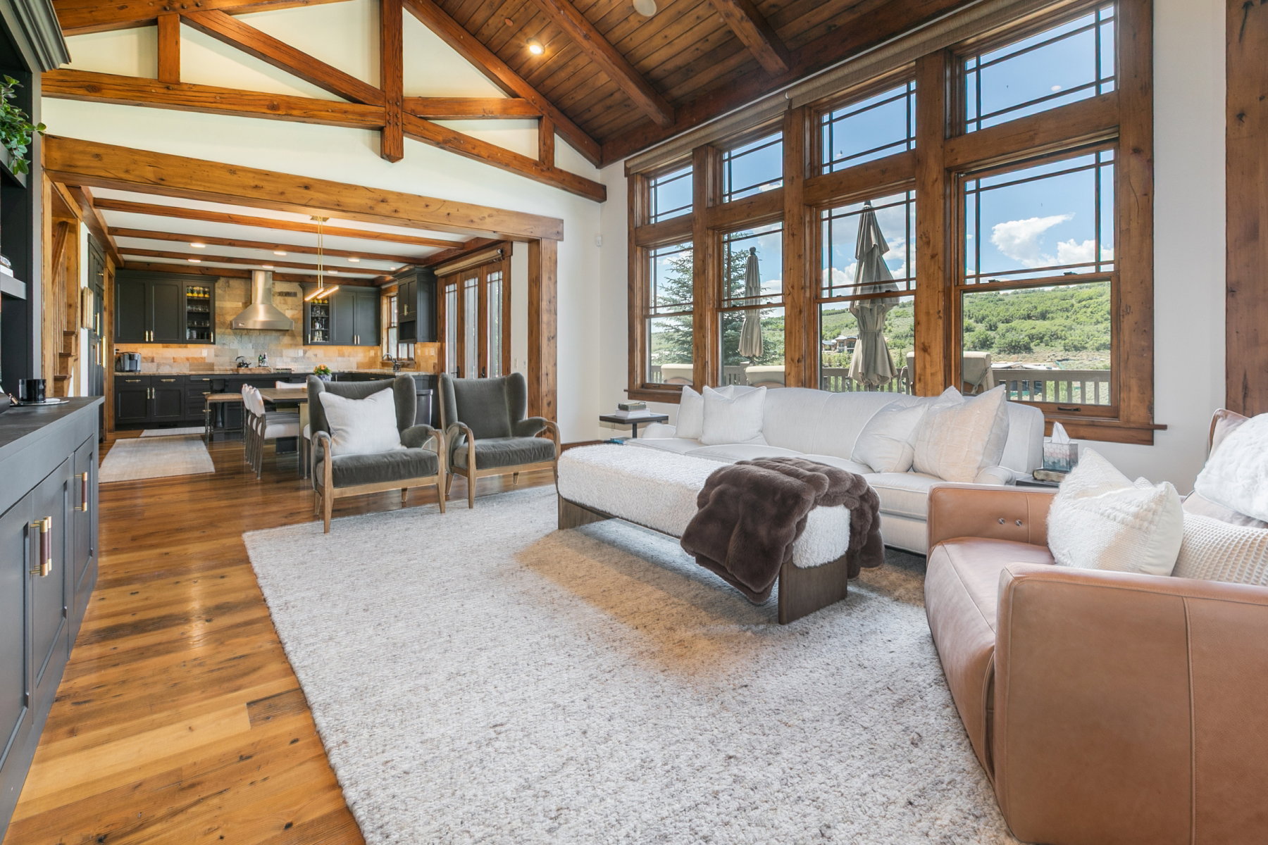 Open-concept living space featuring exposed wood beam ceilings and wood-finish flooring