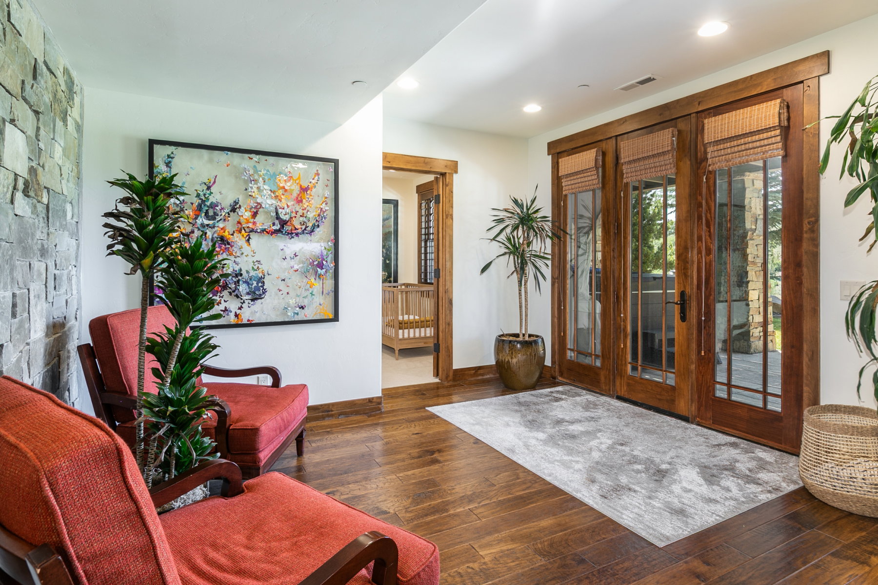 Rich wood-finish flooring complements the natural stone accent wall