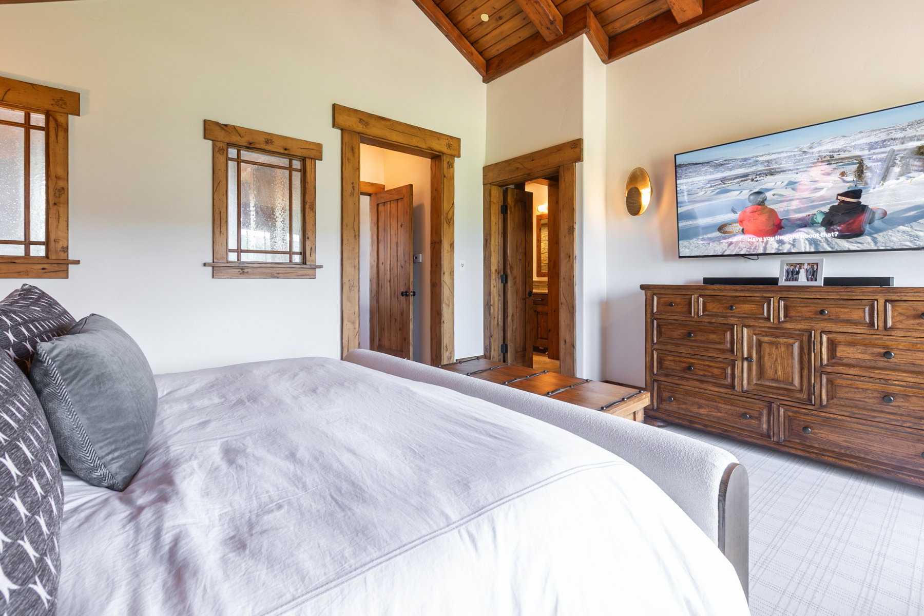 Vaulted wood-beamed ceiling above wood-trimmed windows with textured glass