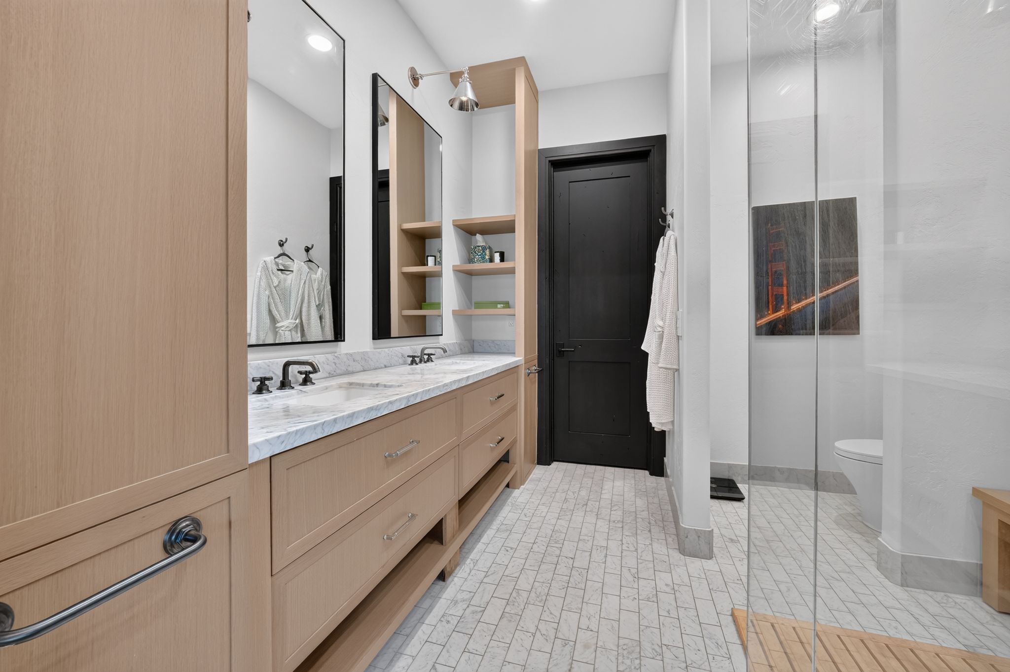 Dual vanity featuring light wood cabinetry, white countertop, and black hardware
