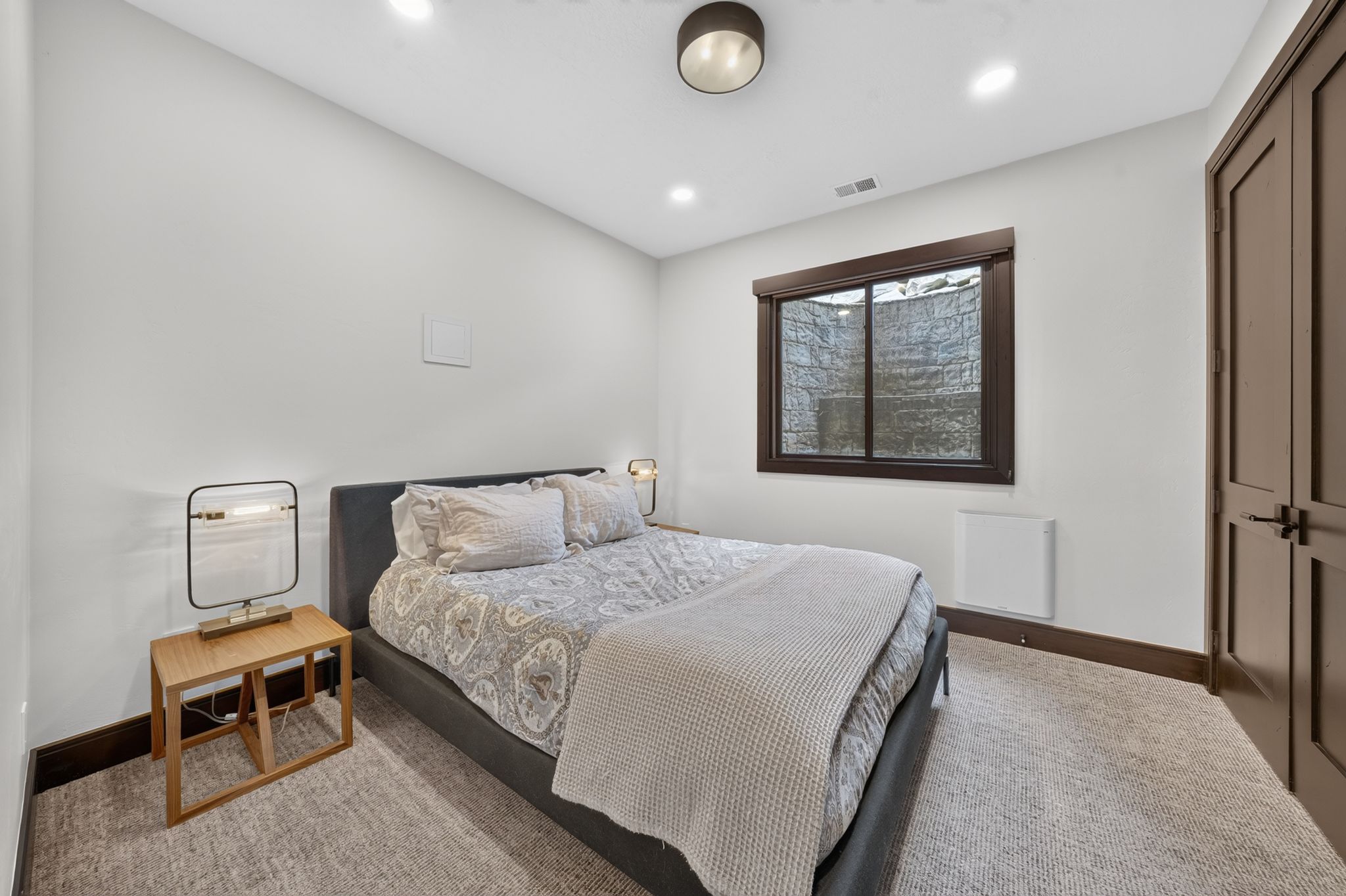 White walls with dark wood trim, recessed lighting, and a carpeted floor