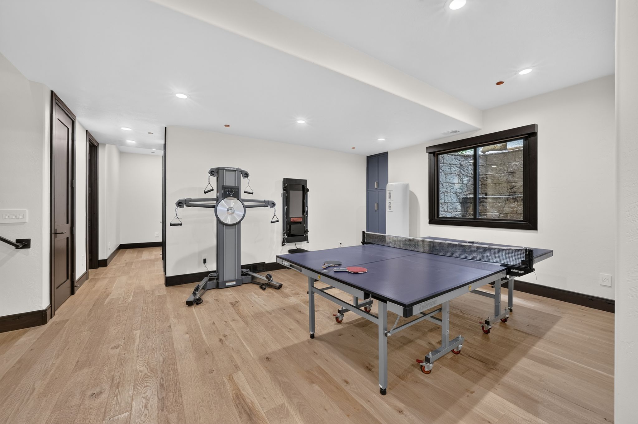 Spacious room featuring wood-finish flooring, recessed lighting, and dark trim