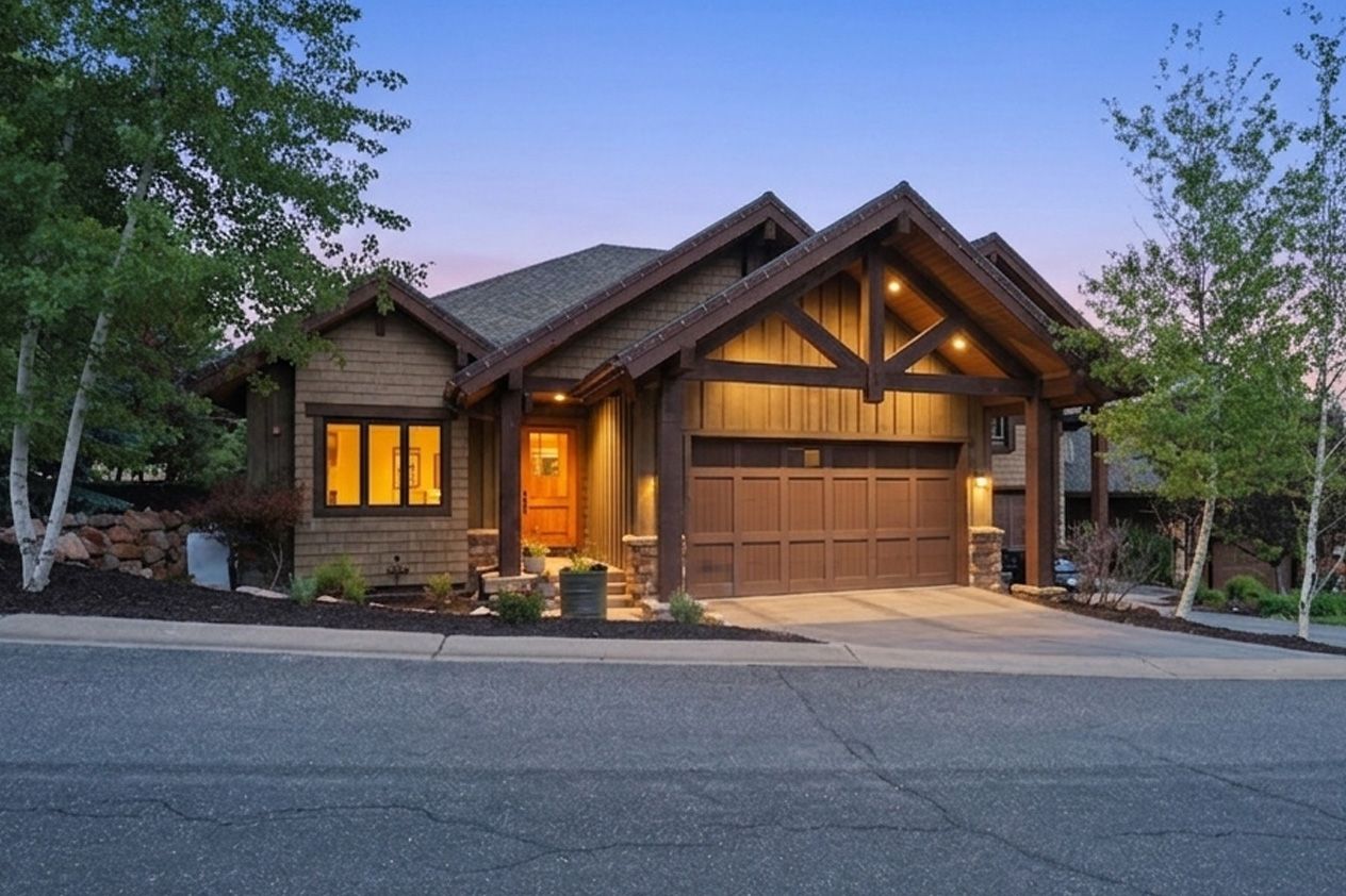 Craftsman-style home featuring a prominent two-car garage with a wood-paneled door