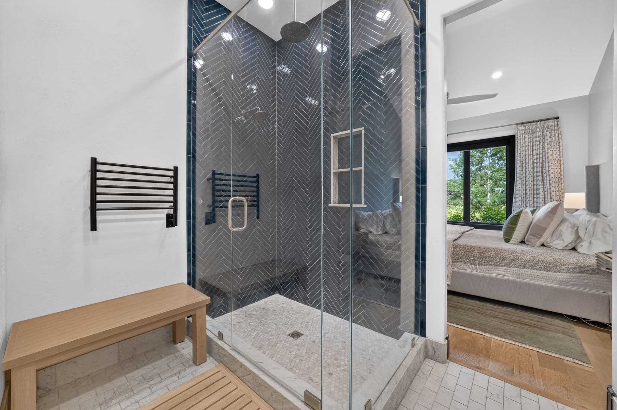 Glass-enclosed shower featuring chevron-patterned wall tile and a built-in niche