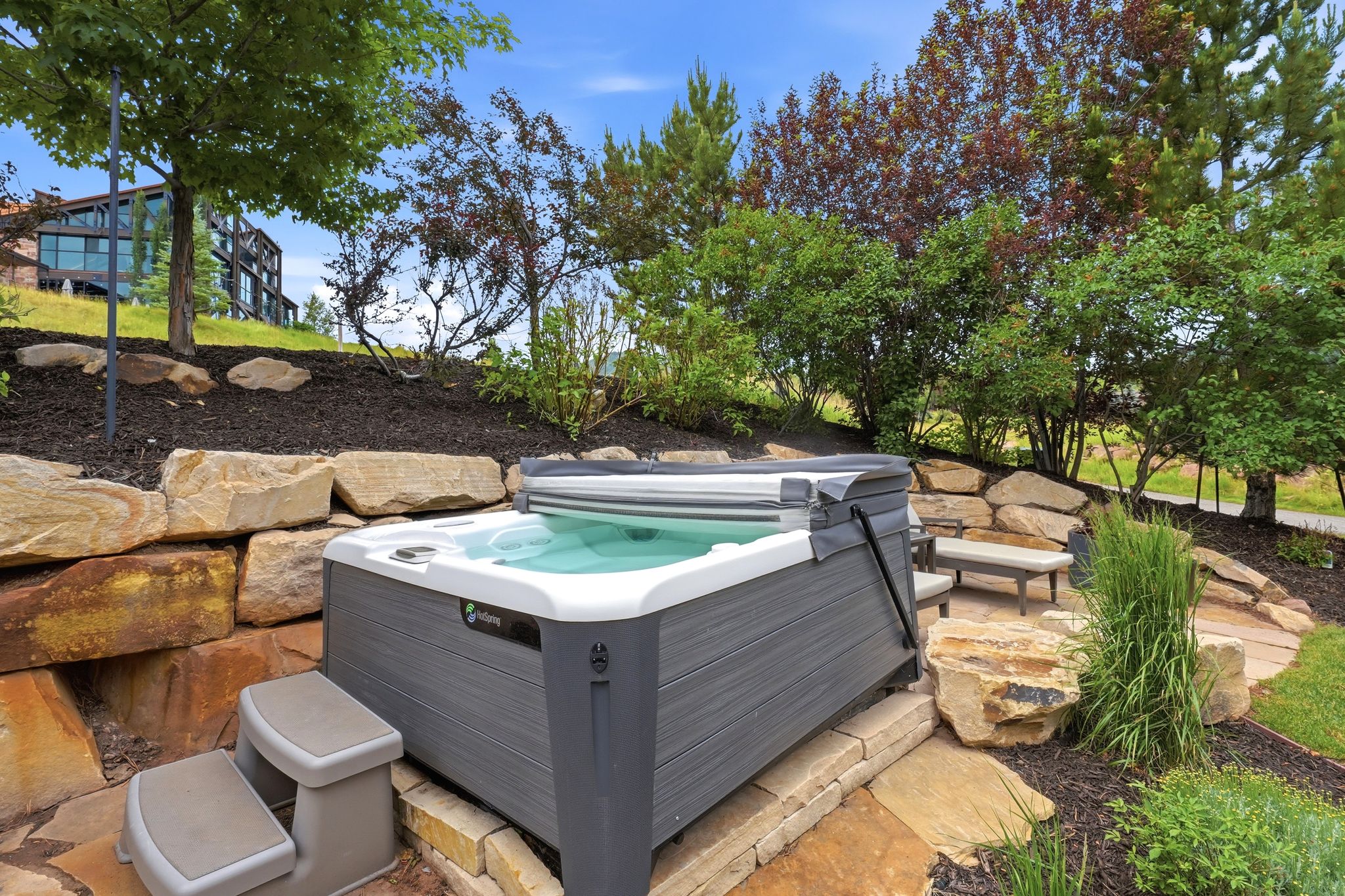 Outdoor spa with a stone retaining wall and integrated patio area