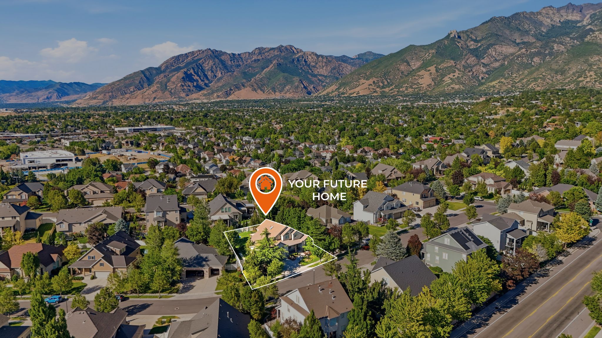 Aerial perspective highlighting a residential property within a tree-lined neighborhood, featuring a prominent mountainous backdrop