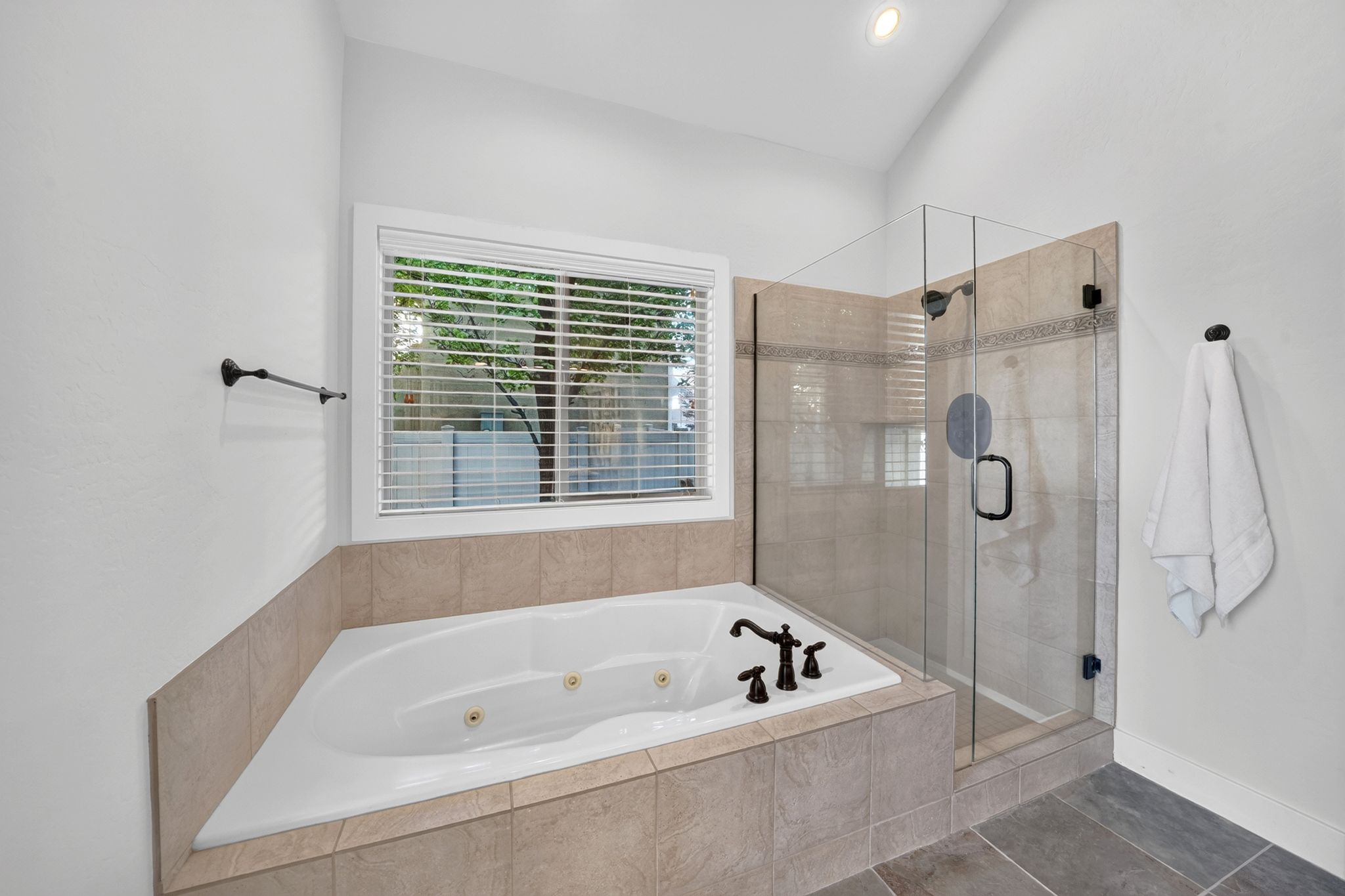 Soaking tub and glass-enclosed shower with tiled surround