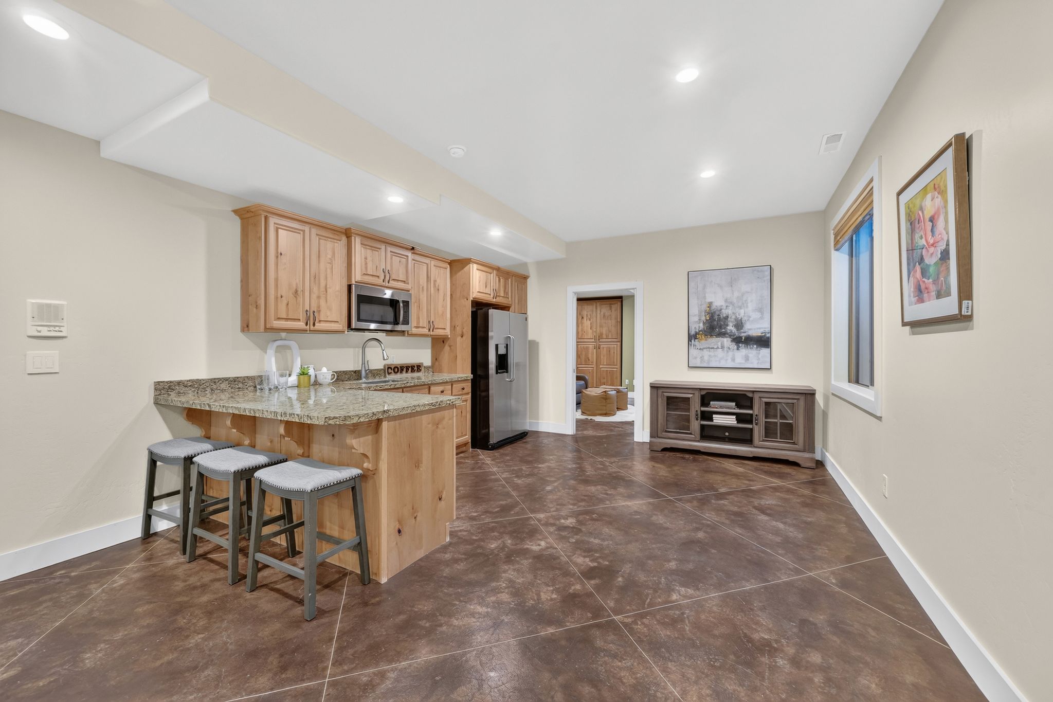 Open concept living area featuring wood-finish flooring, recessed lighting, and a built-in kitchen