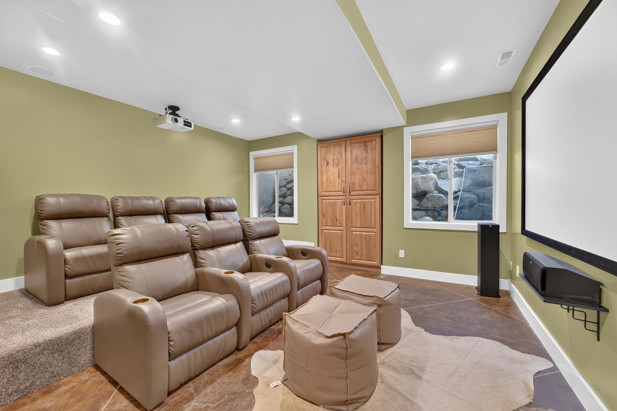 Dedicated media room featuring a mounted projector and large projection screen