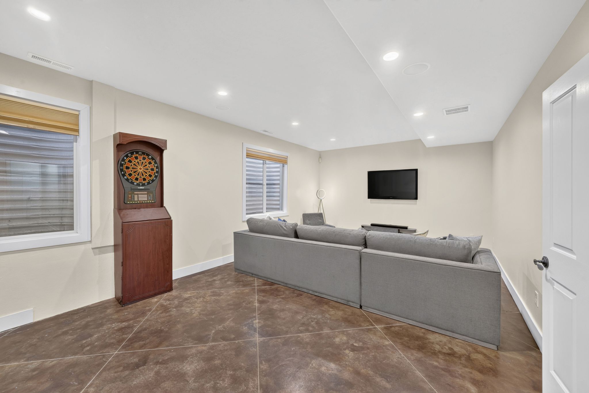 Spacious recreation area featuring large format tile flooring and recessed lighting