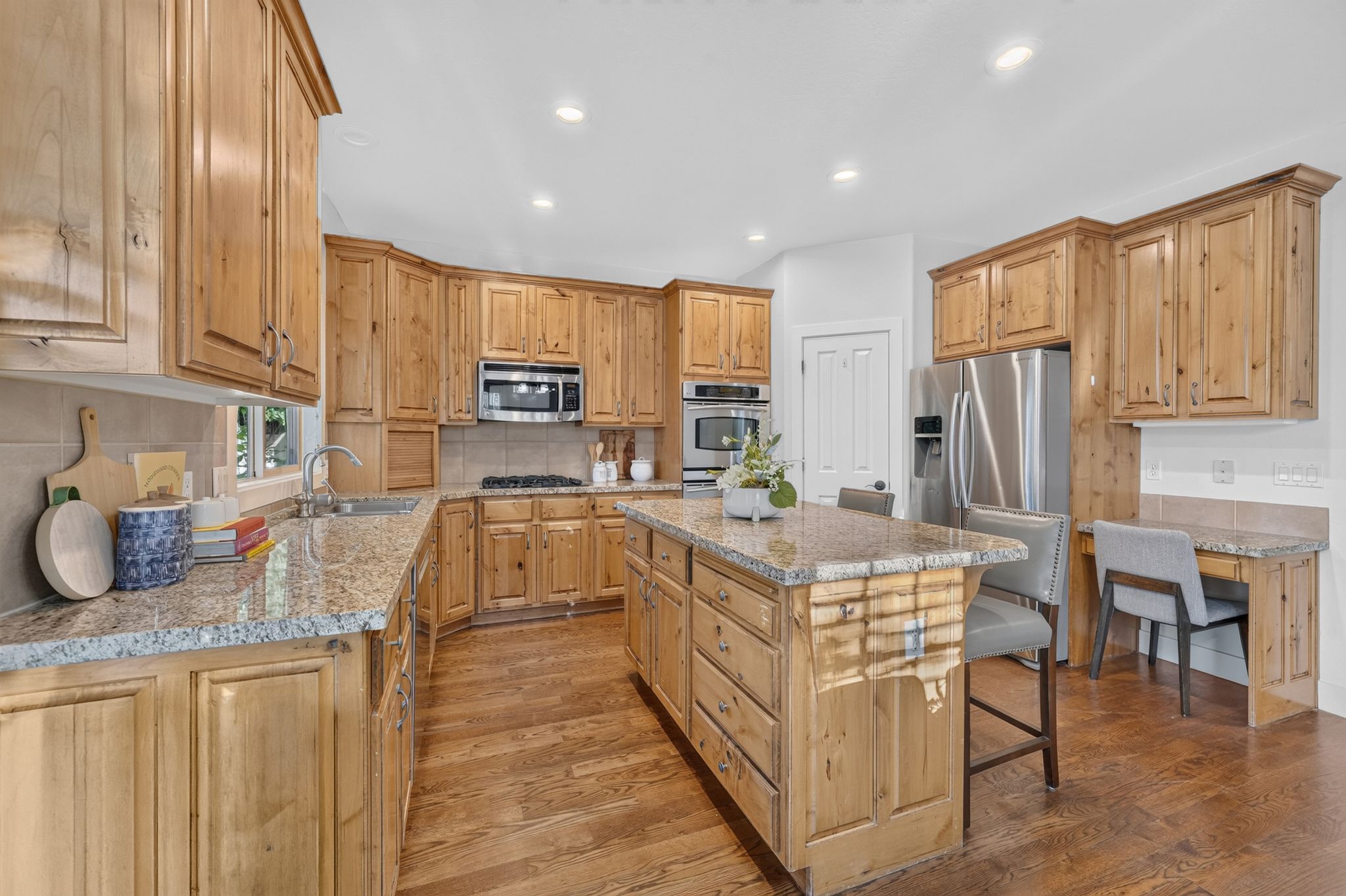 Spacious kitchen featuring wood-finish cabinetry, granite countertops, and stainless steel appliances