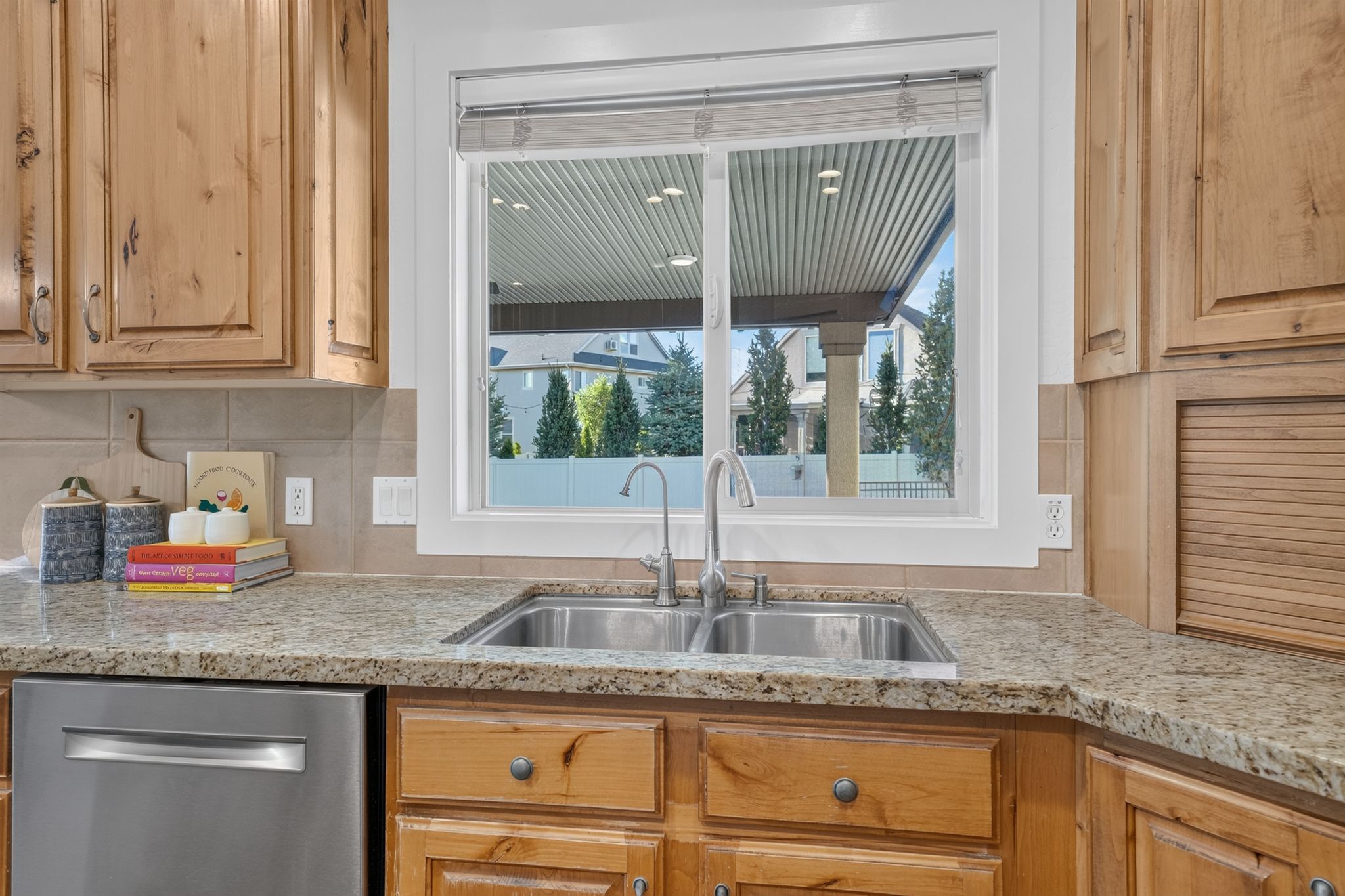 Kitchen sink with a dual basin, stainless steel faucet, and granite-finish countertops
