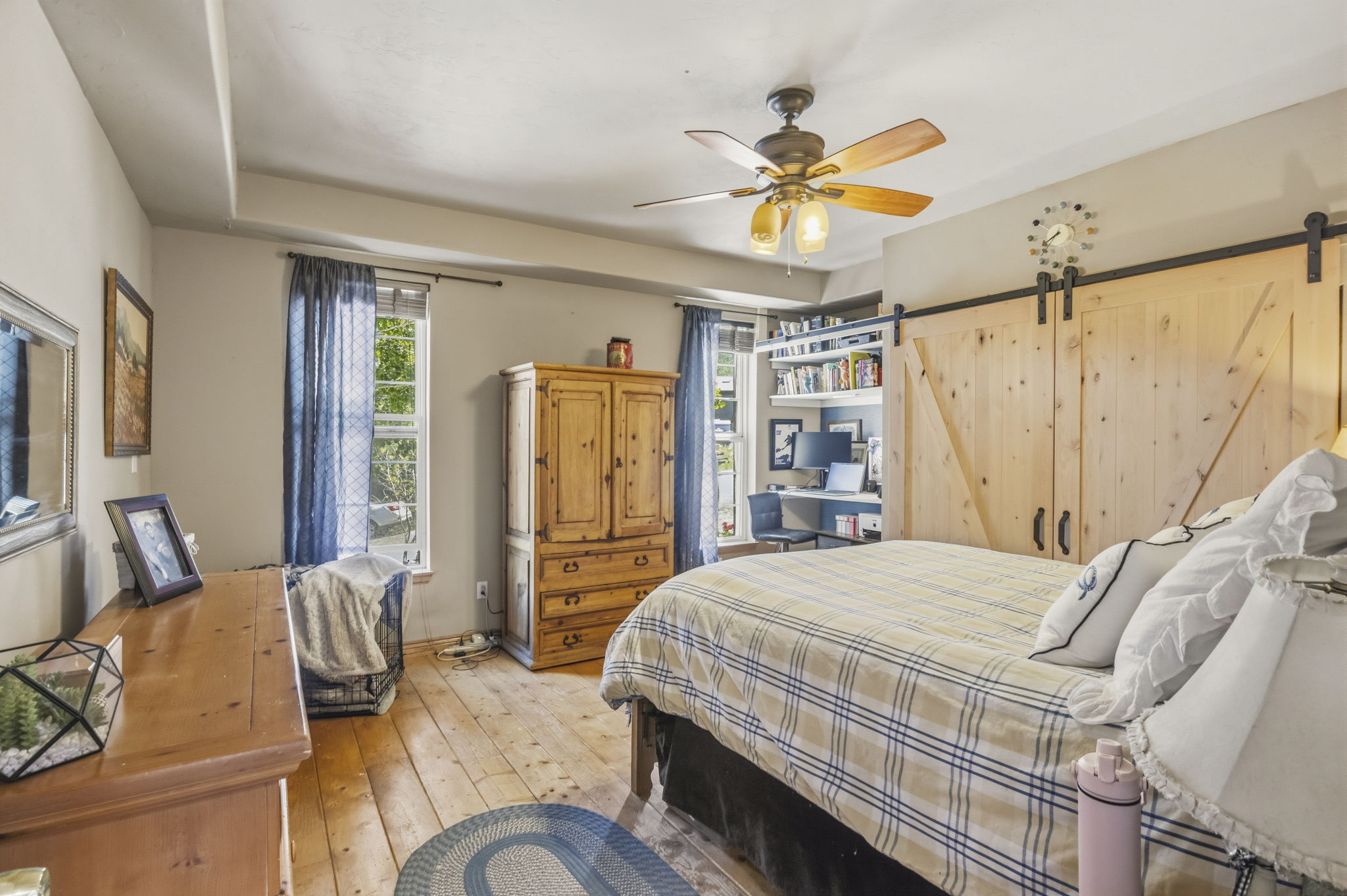 Wood-finish flooring throughout the room with a ceiling fan