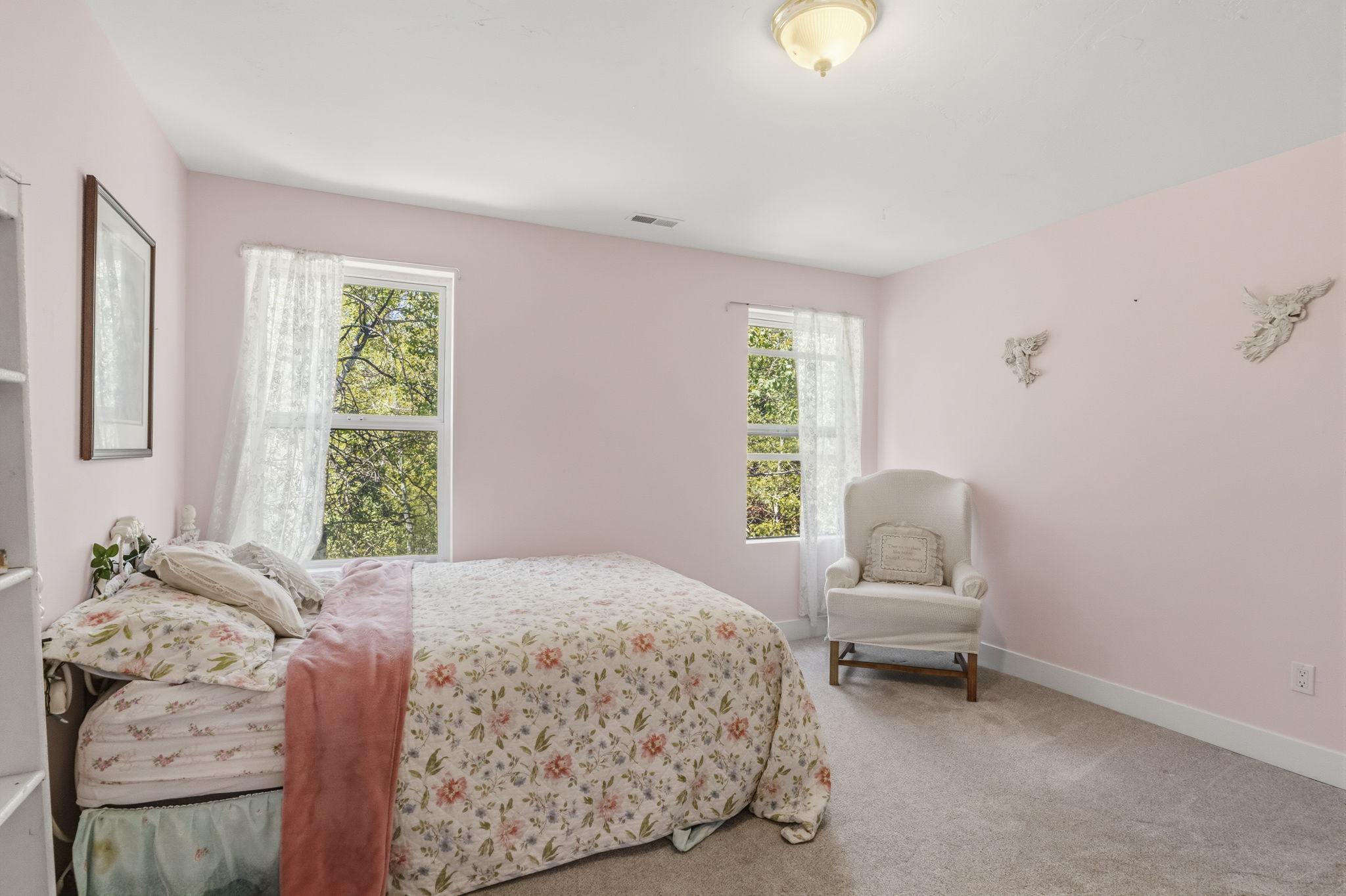 Carpeted room featuring two large windows, a ceiling-mounted light fixture, and white baseboards