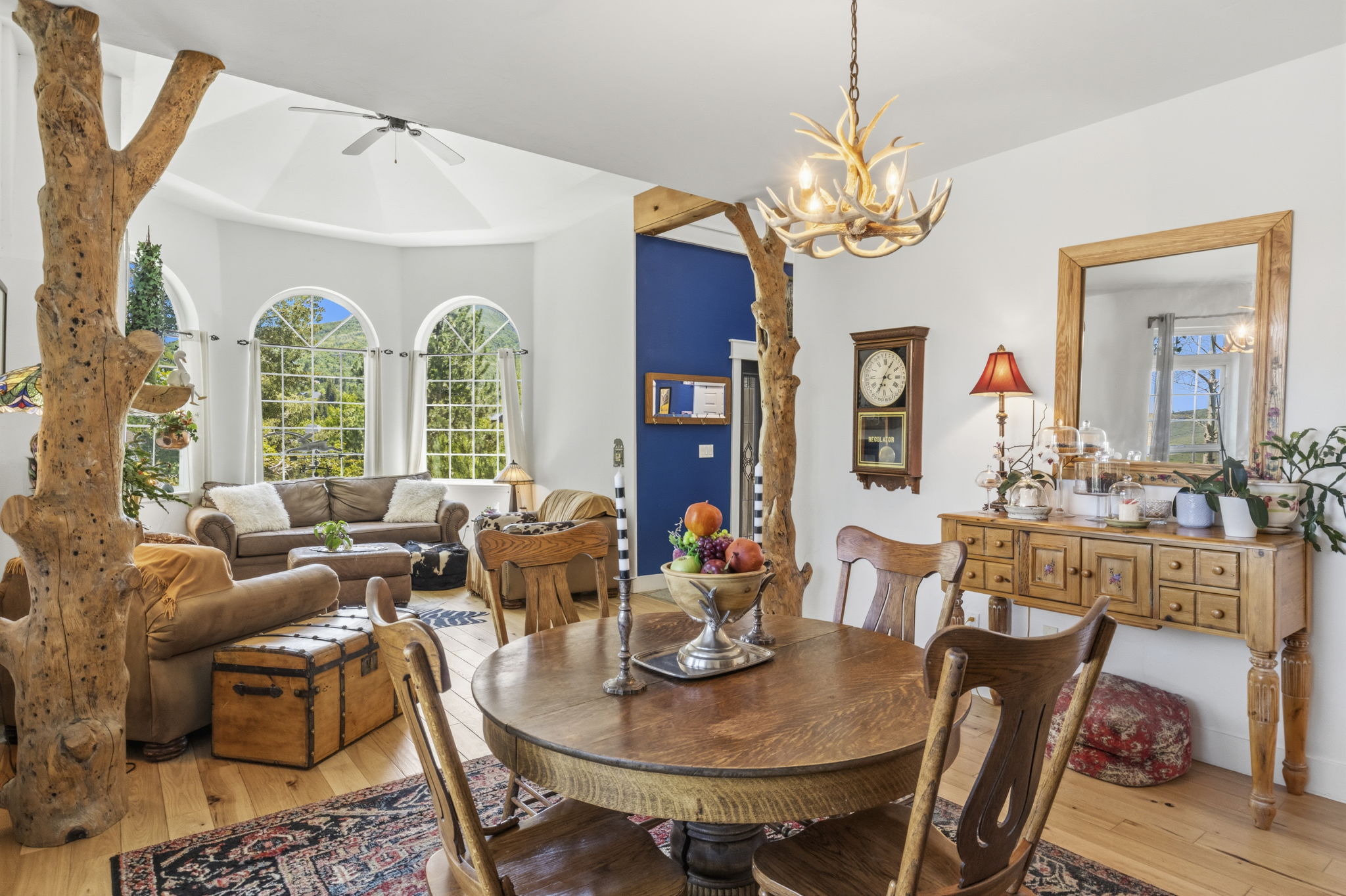 Dining area featuring a rustic antler chandelier and a wooden round table