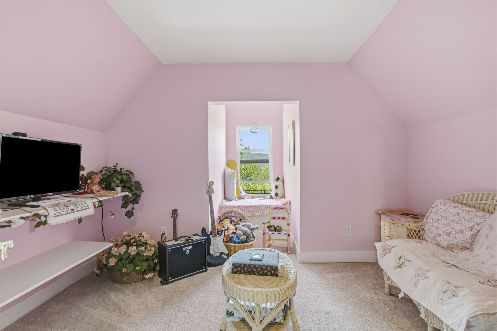 Carpeted room featuring a built-in window seat, sloped ceilings, and light pink painted walls