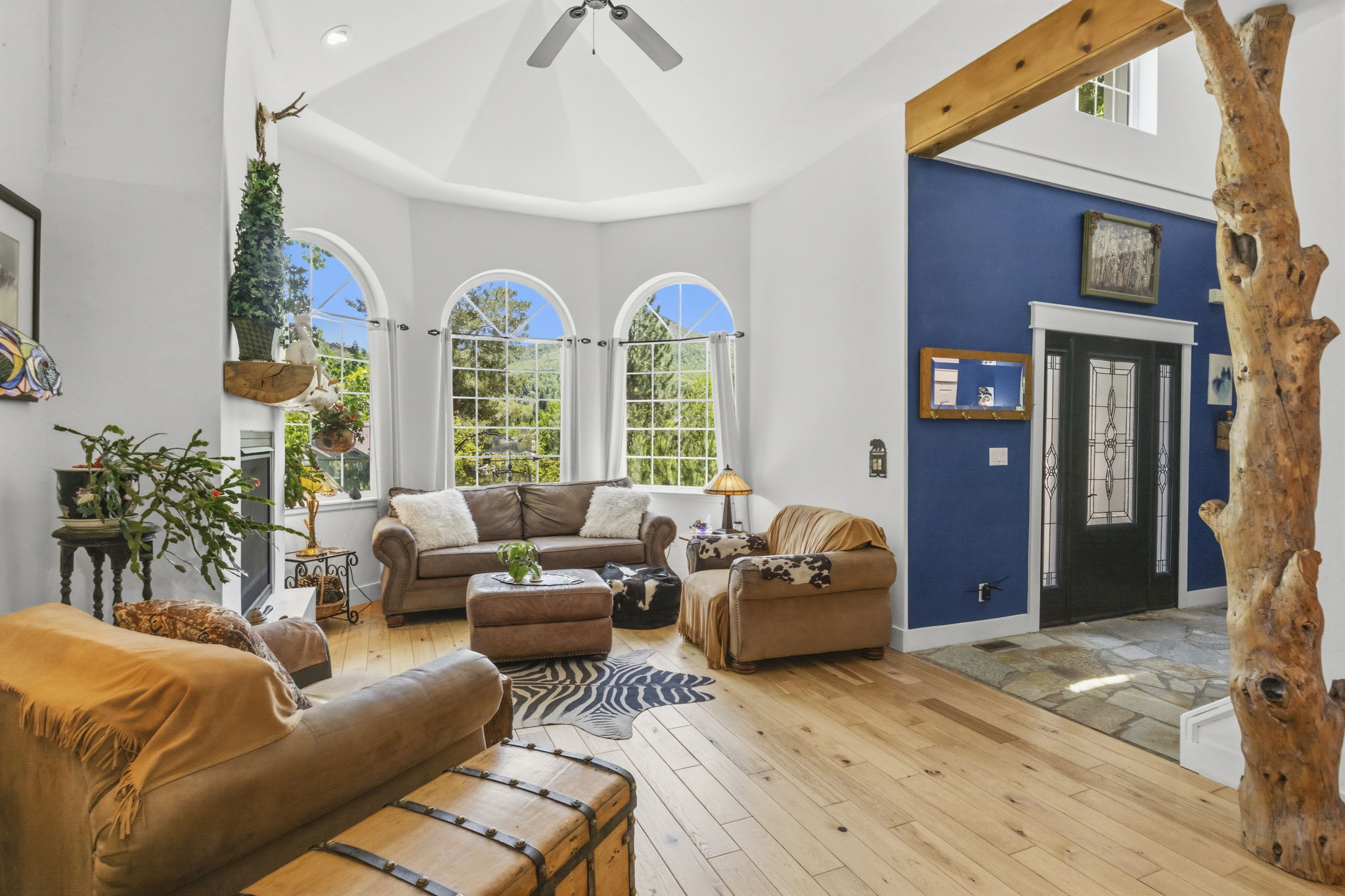 Spacious living area featuring light wood-finish flooring and a distinctive natural wood pillar
