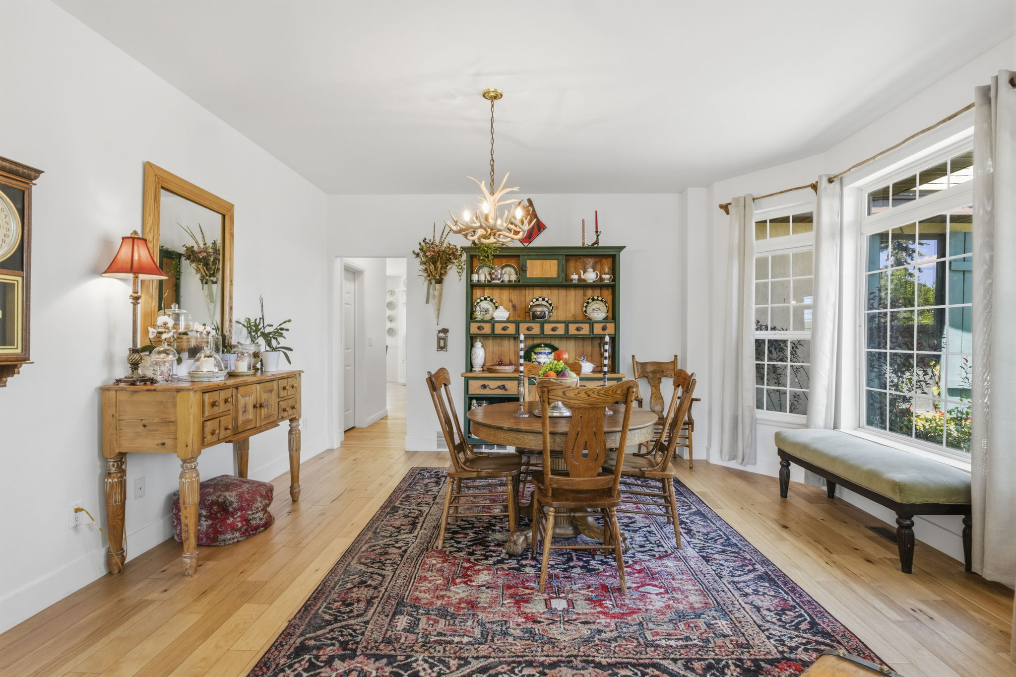 Dining area featuring wood-finish flooring, a contemporary chandelier, and a built-in display hutch