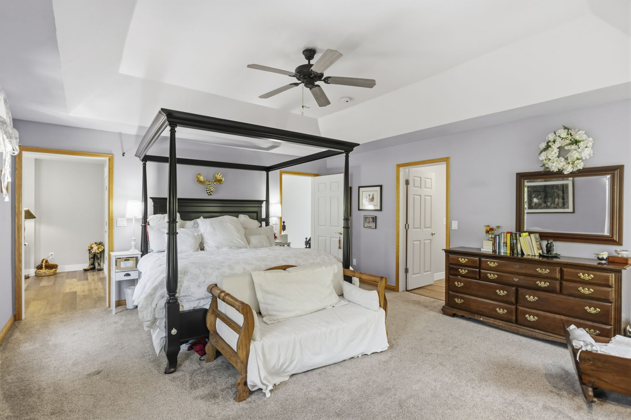 Spacious bedroom featuring a tray ceiling, recessed lighting, and a ceiling fan
