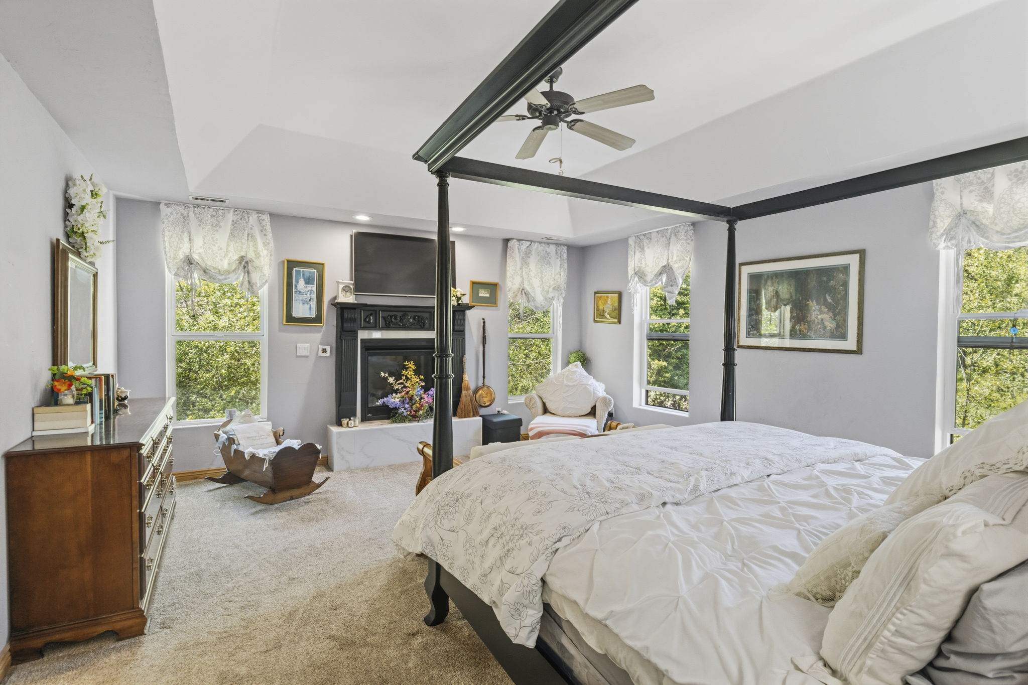 Spacious room featuring a tray ceiling, recessed lighting, and a ceiling fan