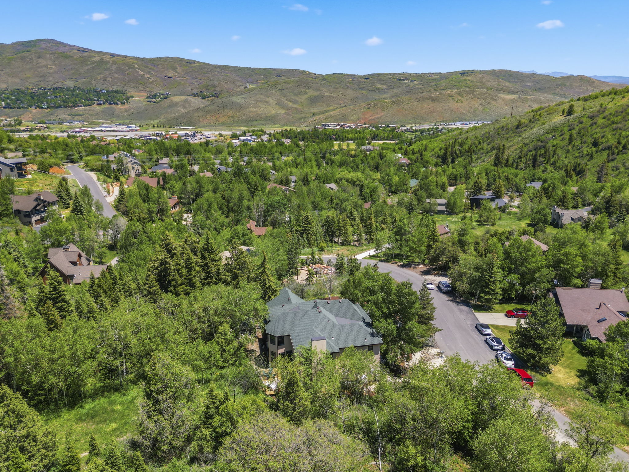 Residential property surrounded by lush green trees and rolling hills